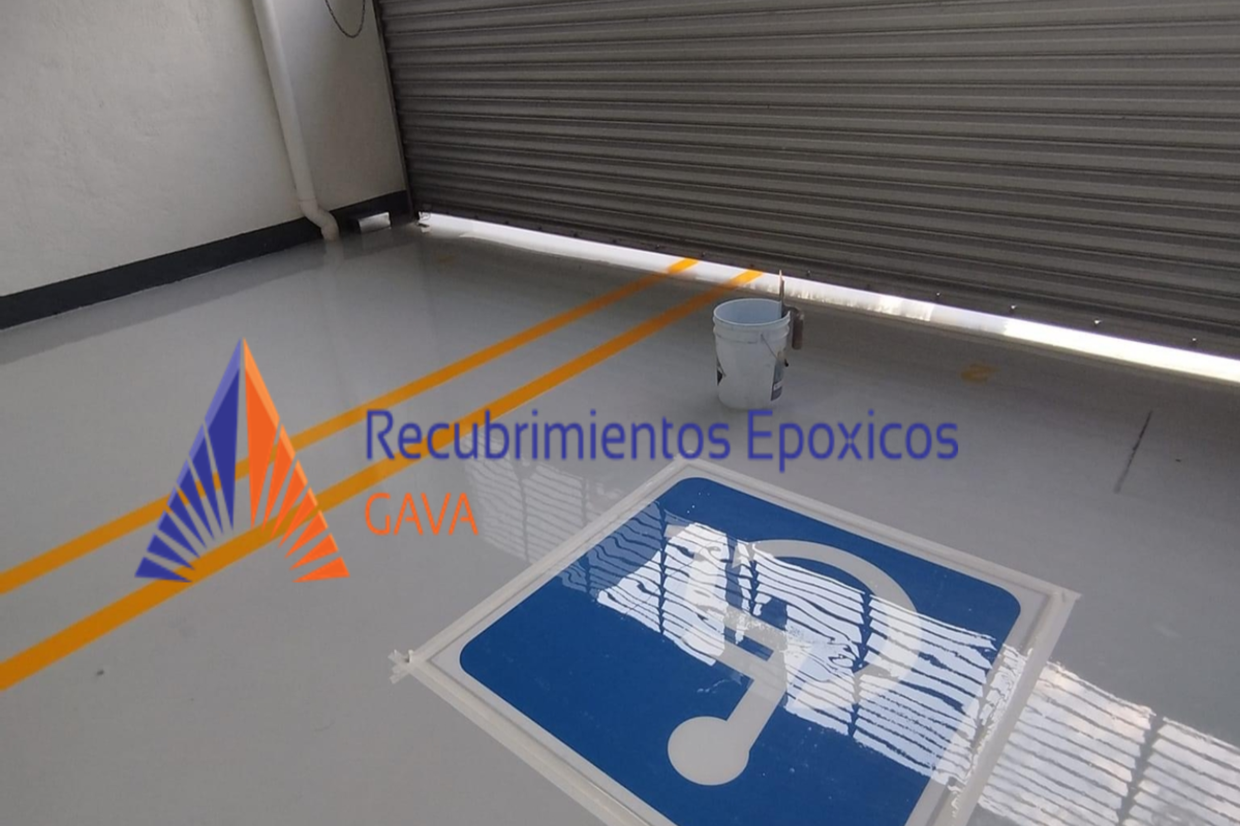 Imagen de un cartel con el logo de GAVA y la leyenda "Recubrimientos Epóxicos" en una superficie de piso junto a una puerta enrollable de metal. También hay una cubeta con brocha o rodillo de pintura.