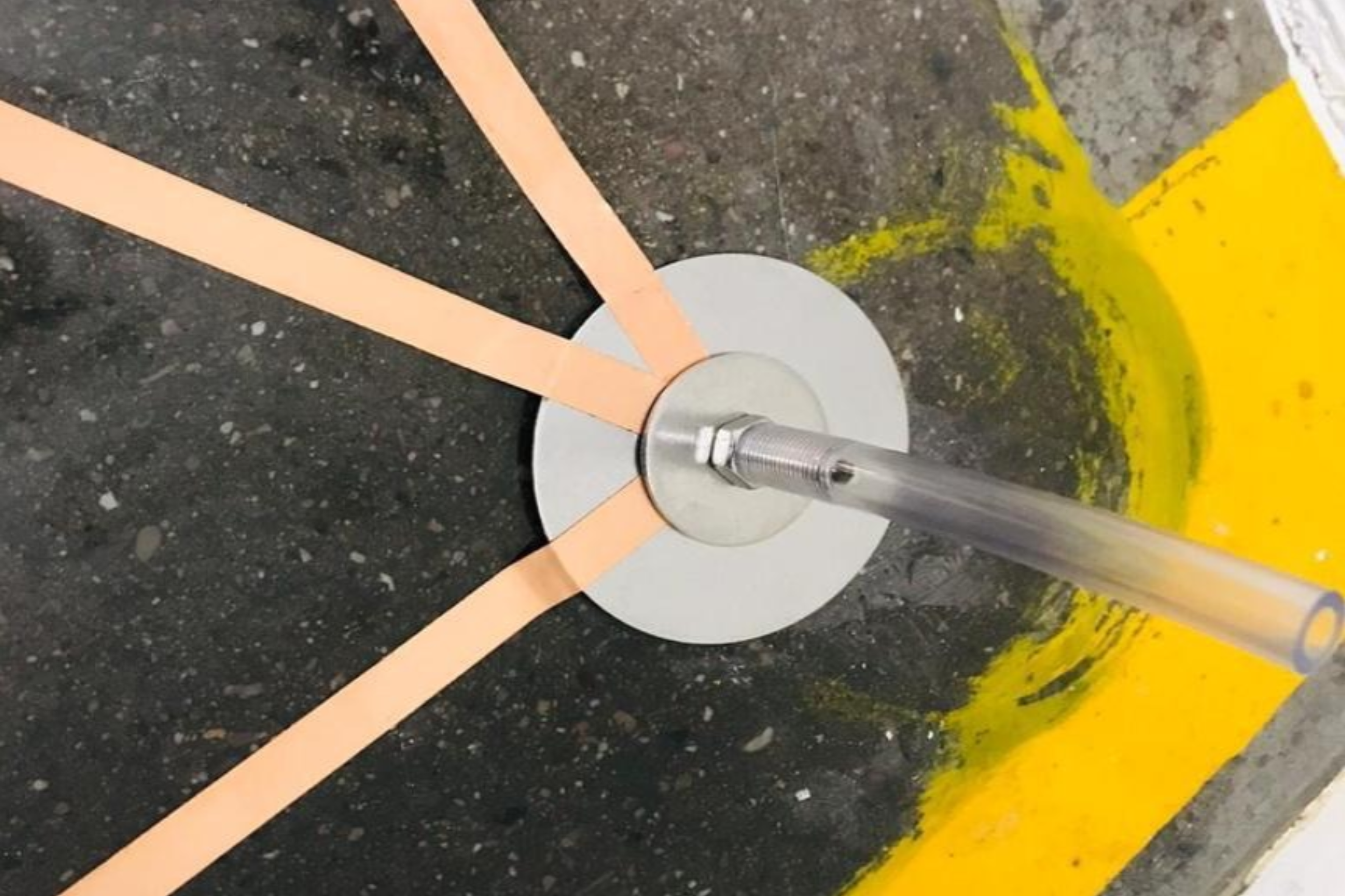 Fregadora sobre línea de pintura amarilla en un piso de concreto.