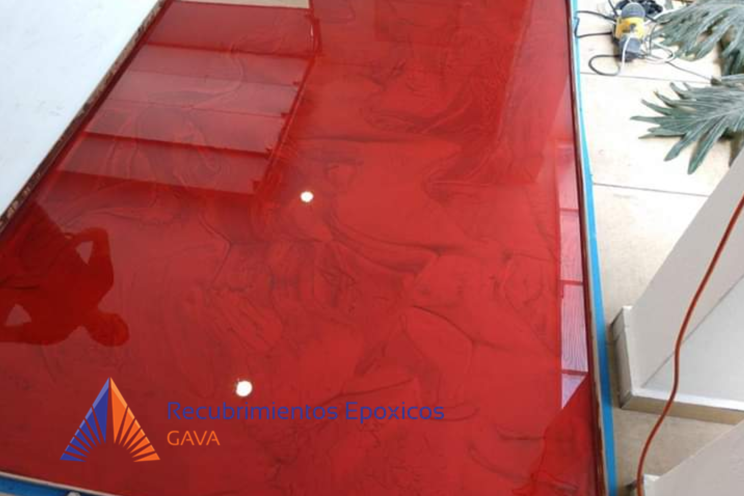 Muestra de recubrimientos epóxicos en color rojo con un logotipo de la empresa en la esquina inferior izquierda y texto en español en la parte inferior que dice 'Recubrimientos Epóxicos GAVA'.