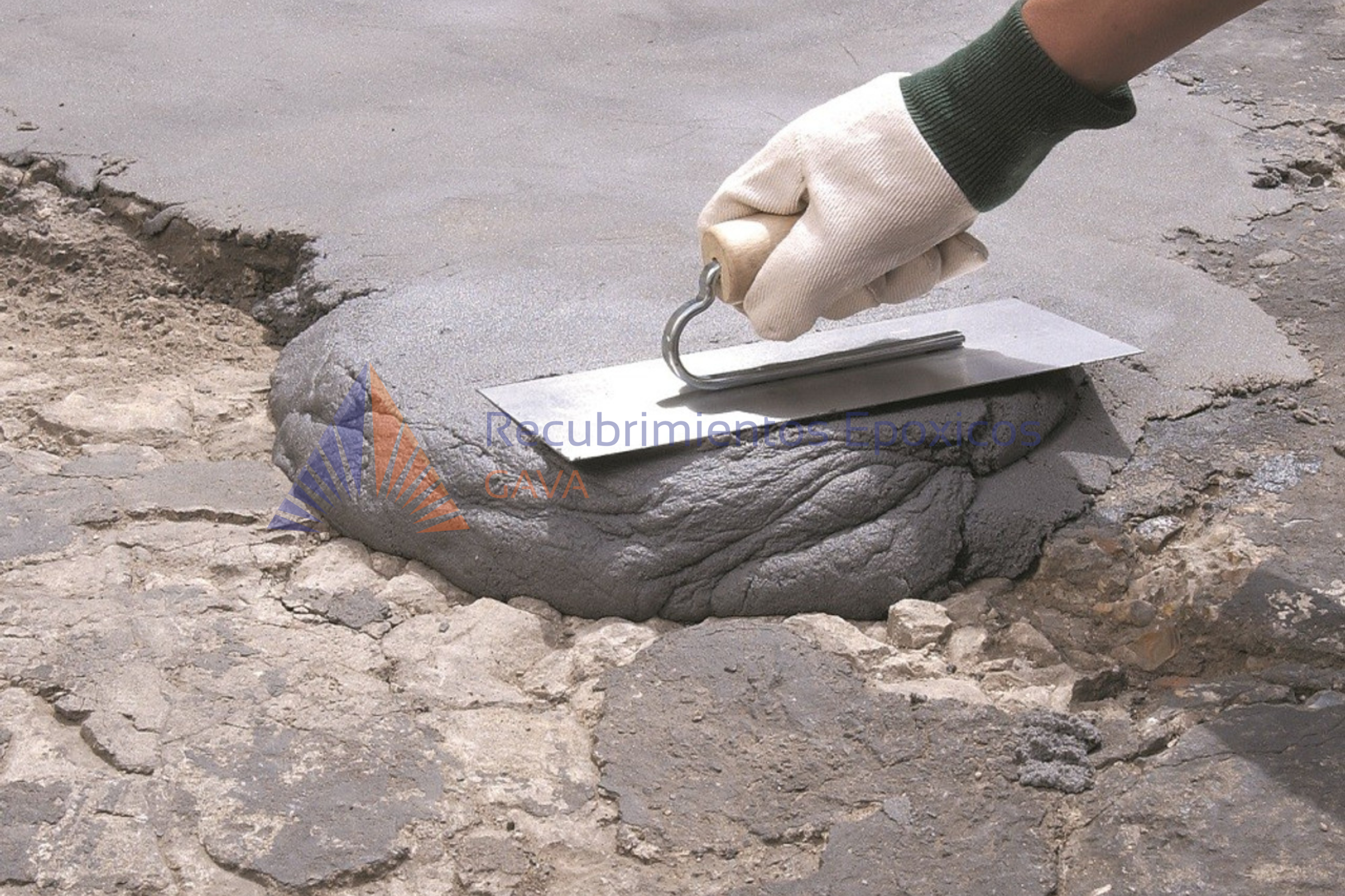 Persona con guante de trabajo usando una herramienta de cortado para preparar cemento en una construcción.