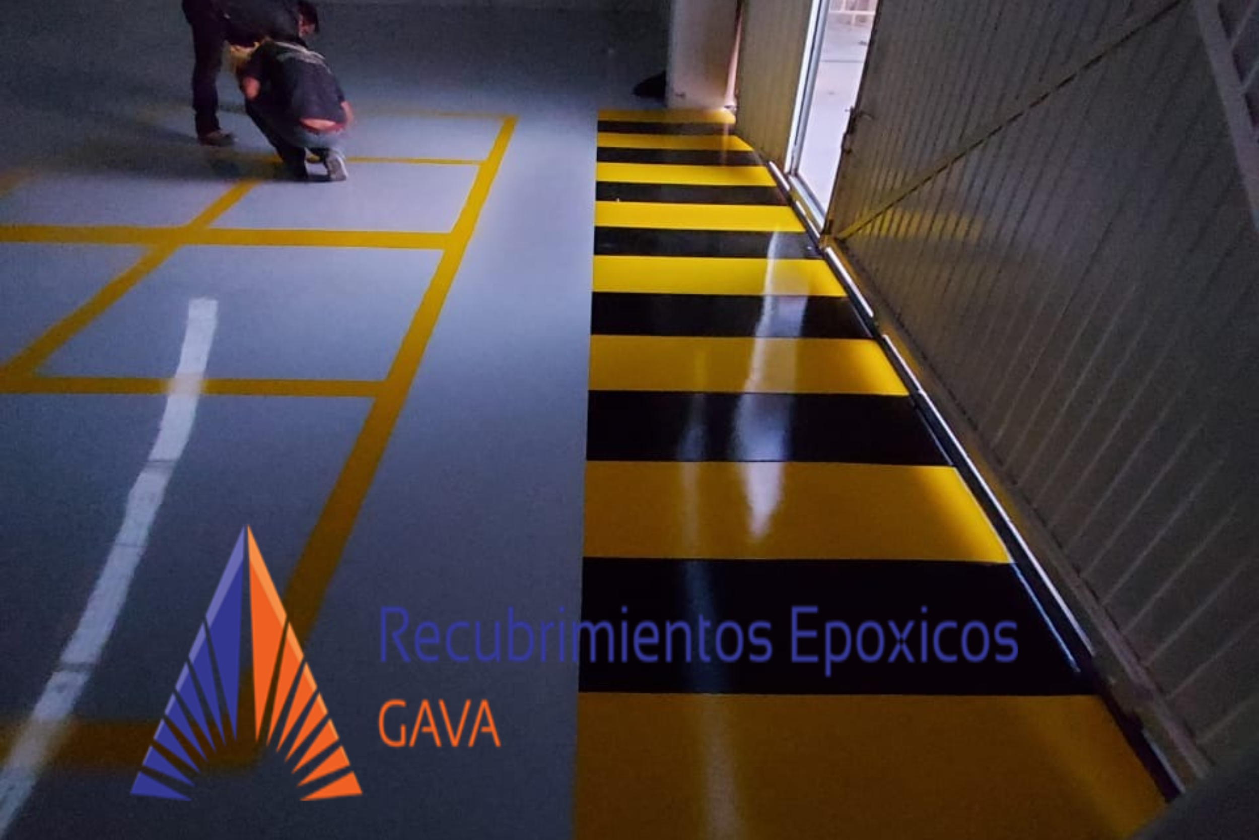 Zona de estacionamiento con marcas amarillas y negras y un cartel que dice "Recubrimientos Epóxicos GAVA" en la parte inferior. Dos personas parecen estar inspeccionando el área.