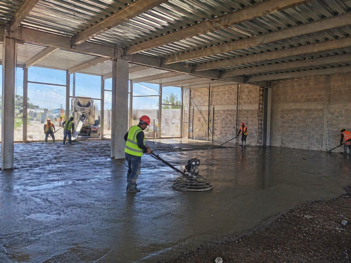 Trabajadores construyendo un suelo de concreto en un edificio en construcción