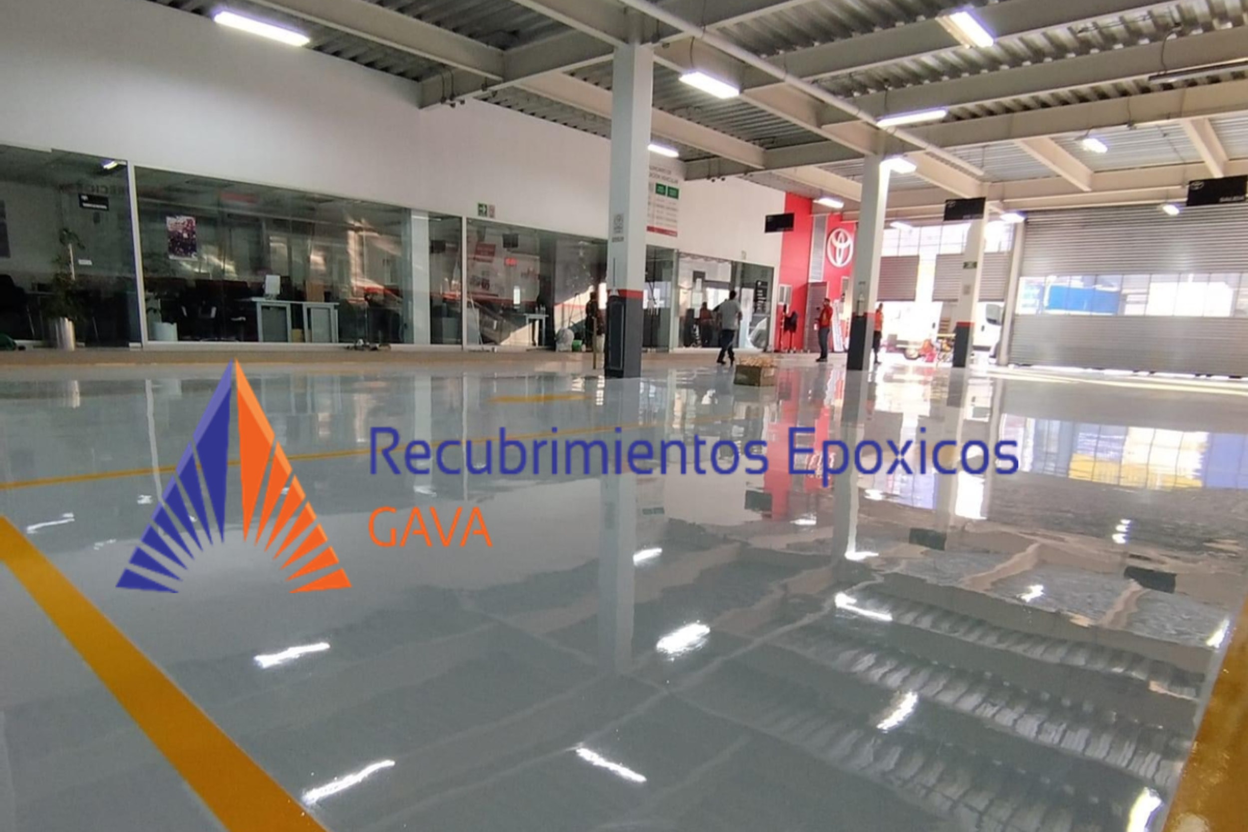 Interior de una estación de servicio con personal atendiendo, logotipo de Toyota visible, y un cartel que dice 'Recubrimientos Epóxicos GAVA' en primer plano.
