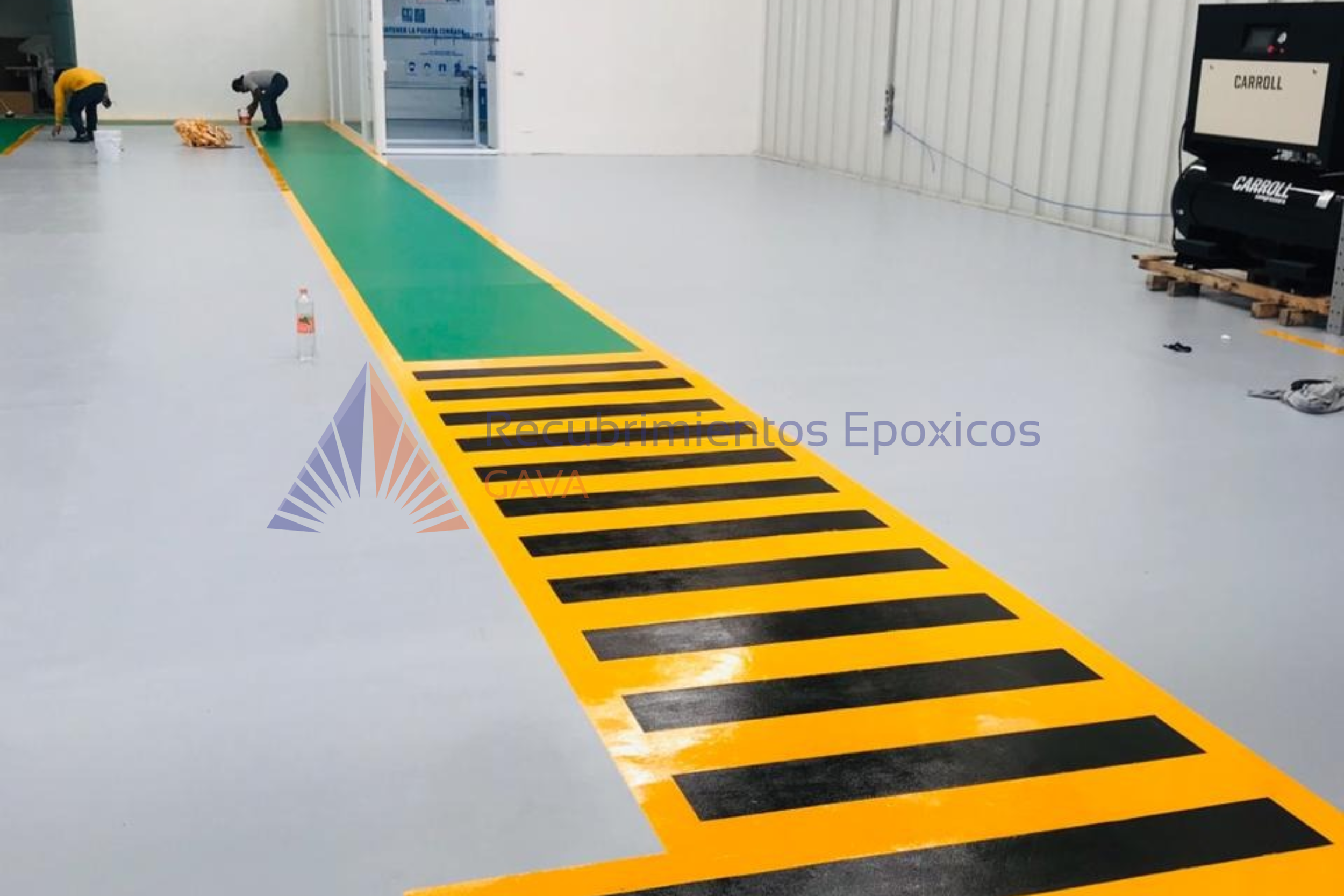 Suelo con línea verde y marcas negras y amarillas en un espacio industrial.