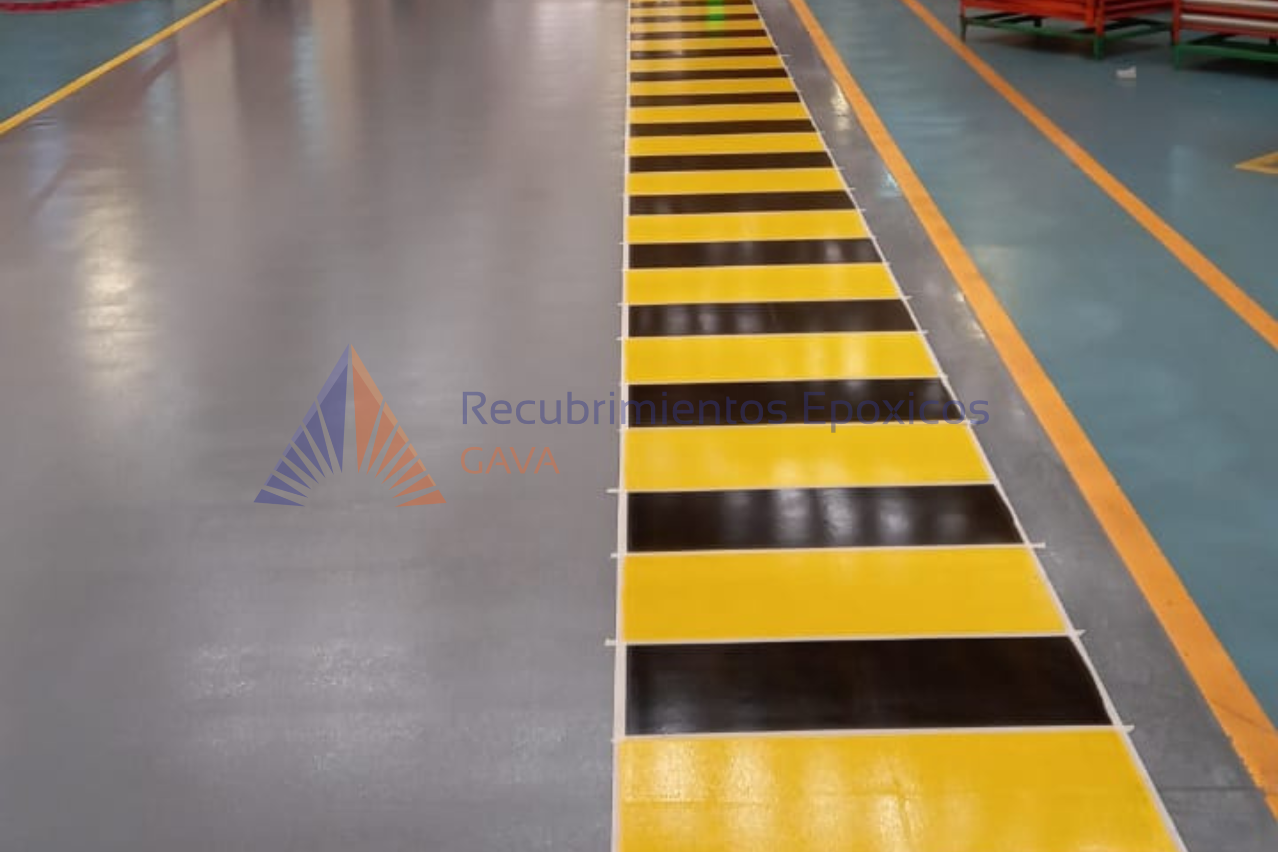 Zona de seguridad con franjas blancas, amarillas y negras en un piso de un entorno industrial.
