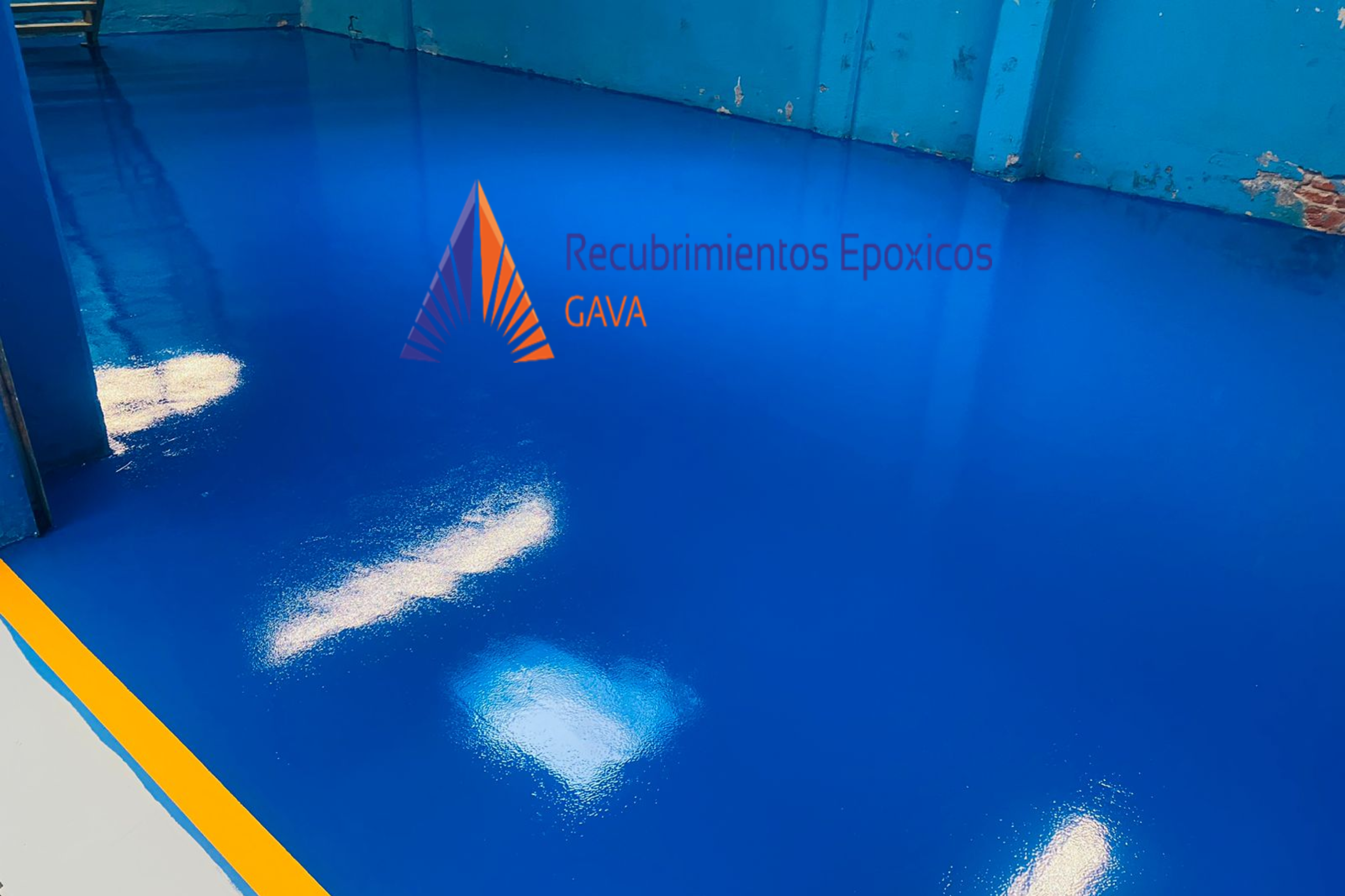 Superficie de piso azul brillante con texto que dice "Recubrimientos Epóxicos GAVA" y un logotipo de triángulo con líneas en tonos morados y naranja.