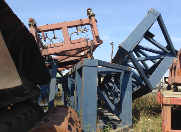 Discarded metal structures and machinery parts stacked outdoors