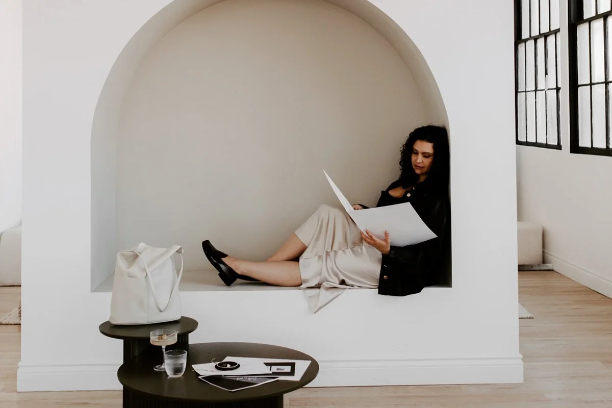 Woman looking through a folder while seated in a built-in credenza.