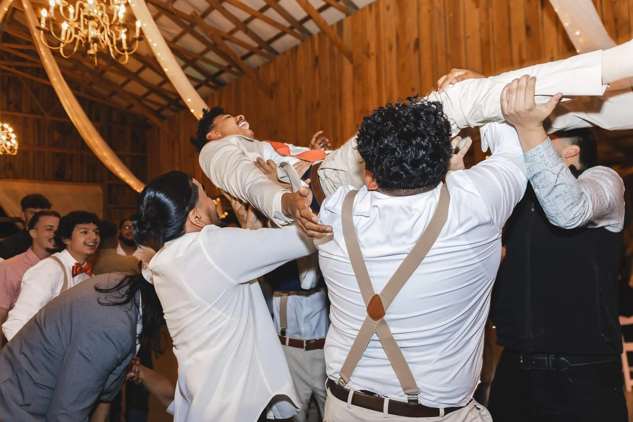Groomsmen lifting the groom in celebration during a lively wedding reception with Bob Marlos Mobile DJ Services keeping the party energized.