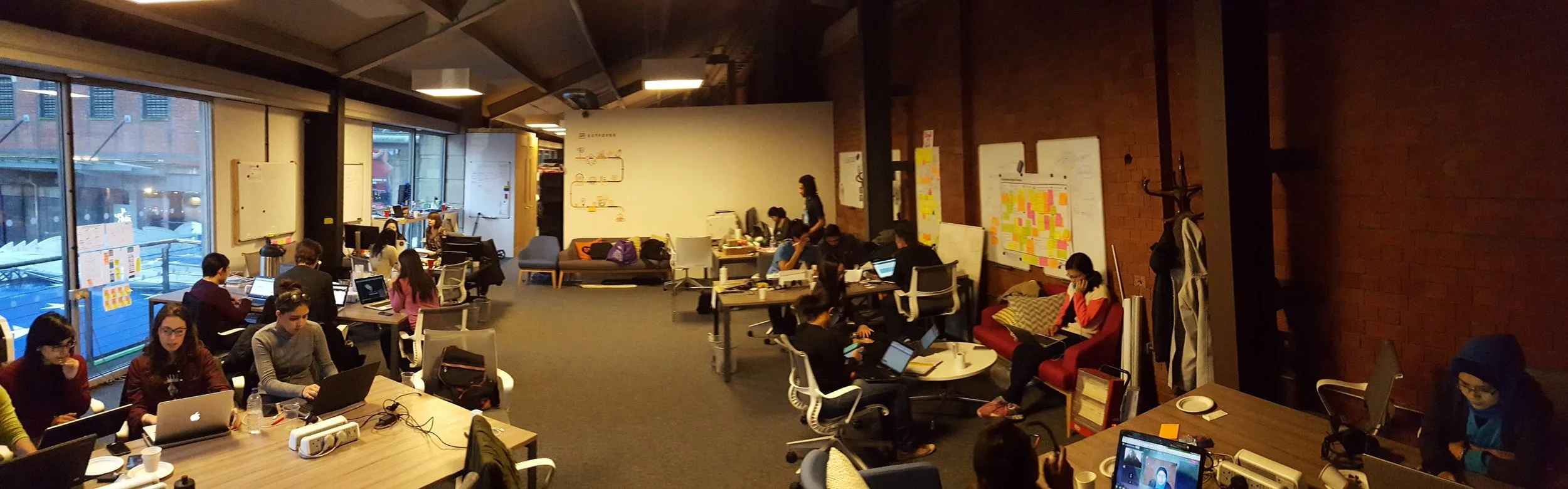 Social Storm participants working in teams across the Manchester event space during the 24-hour hackathon.