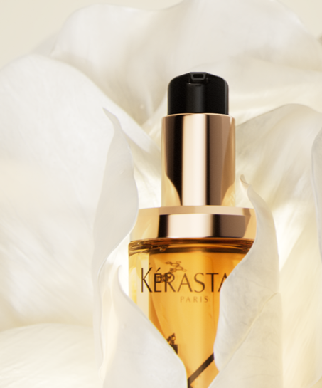 A perfume bottle labeled 'LA WOMAN BODHA' with a gold-colored rock on top, casting shadows on a background with light and dark areas.