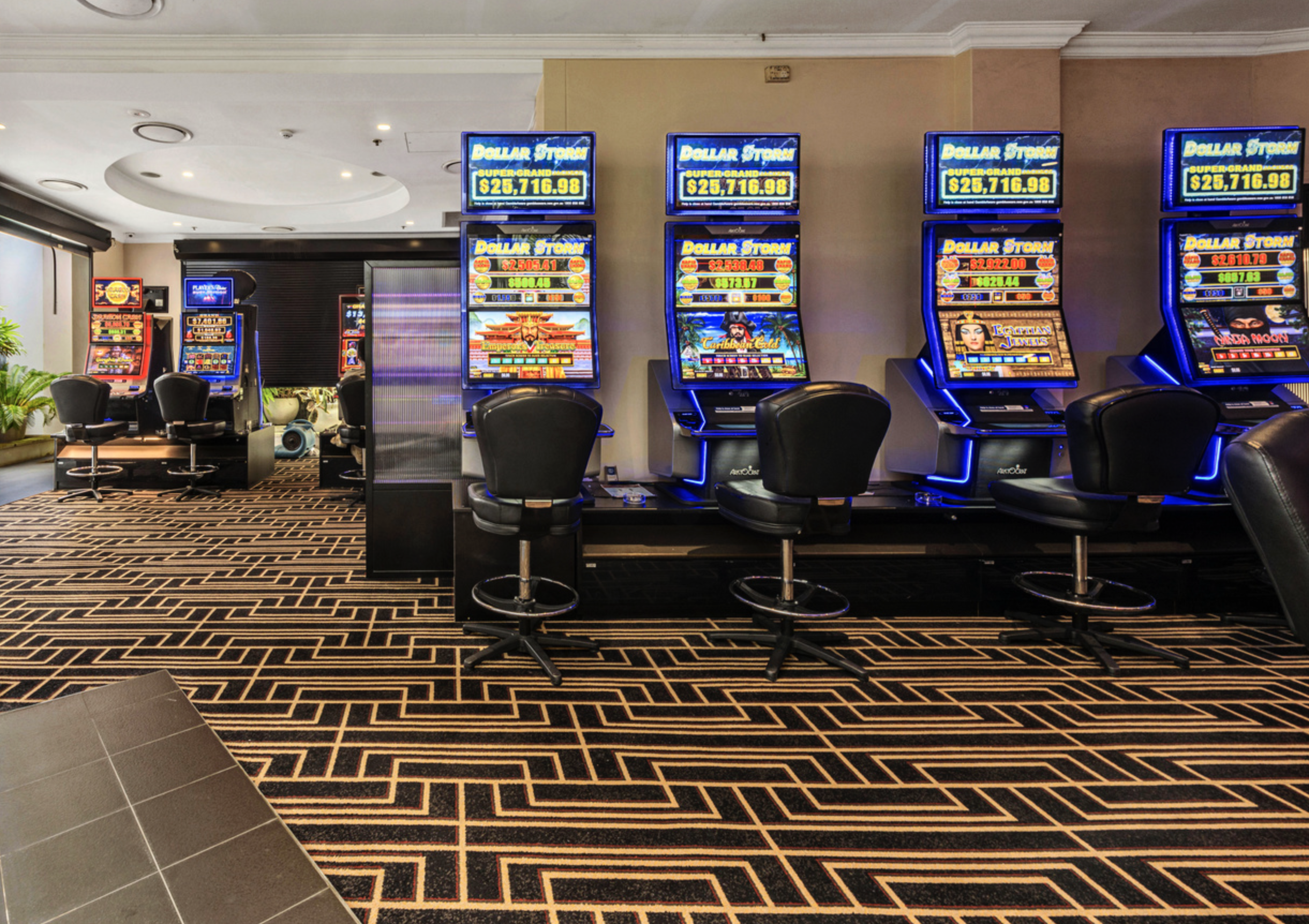 Axminster and Print Hospitality Carpets - suitable to pubs, clubs, hotels, bars: Casino slot machines with colorful screens and chairs in a gaming area.