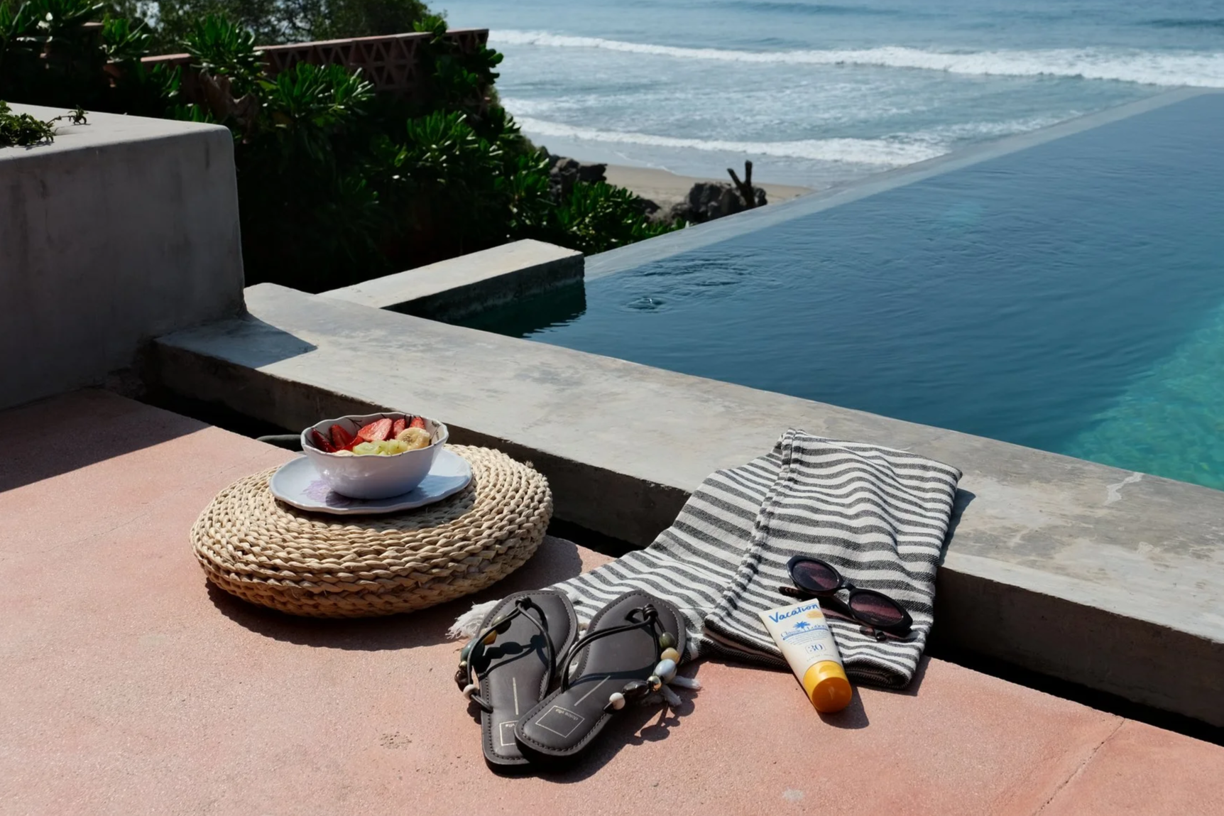 Puerto Escondido packing essentials flat lay: sandals, sunscreen, and beach towel