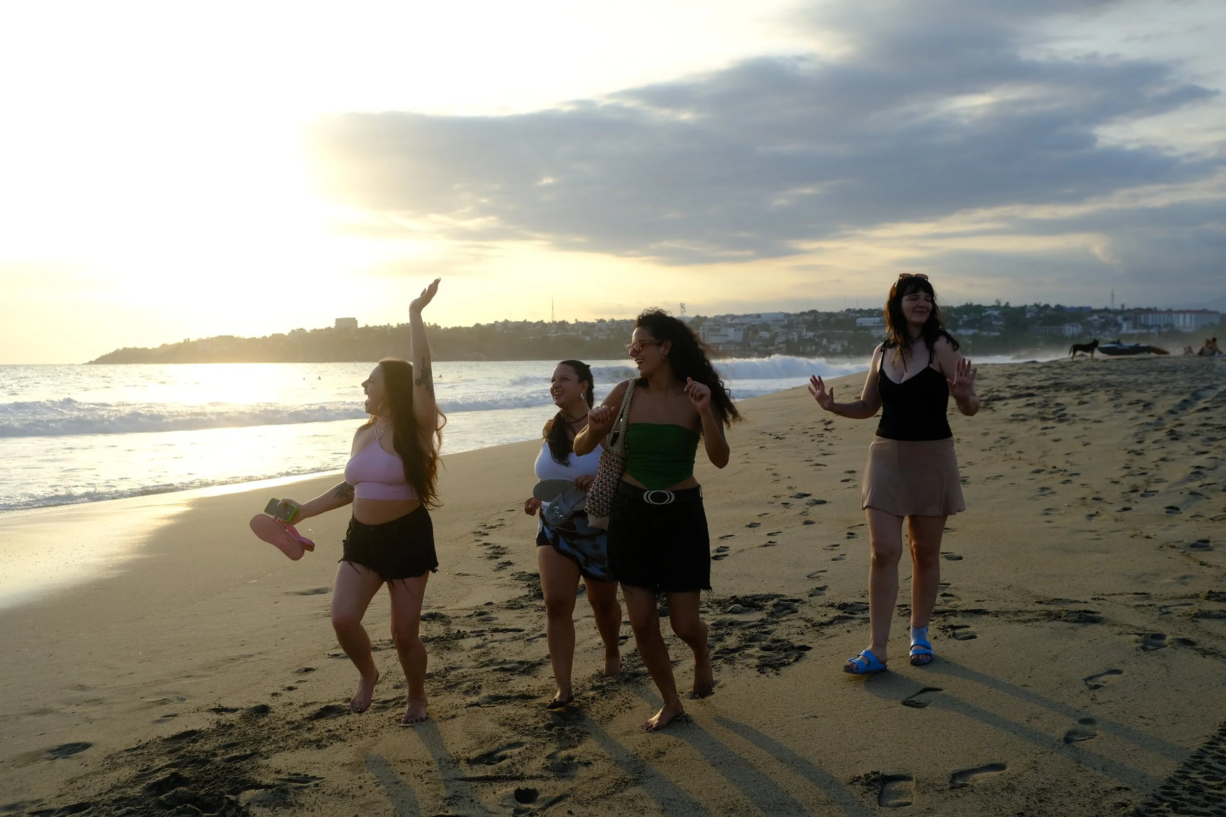Friends dancing on the beach at sunset, northern Zicatela, Puerto Escondido