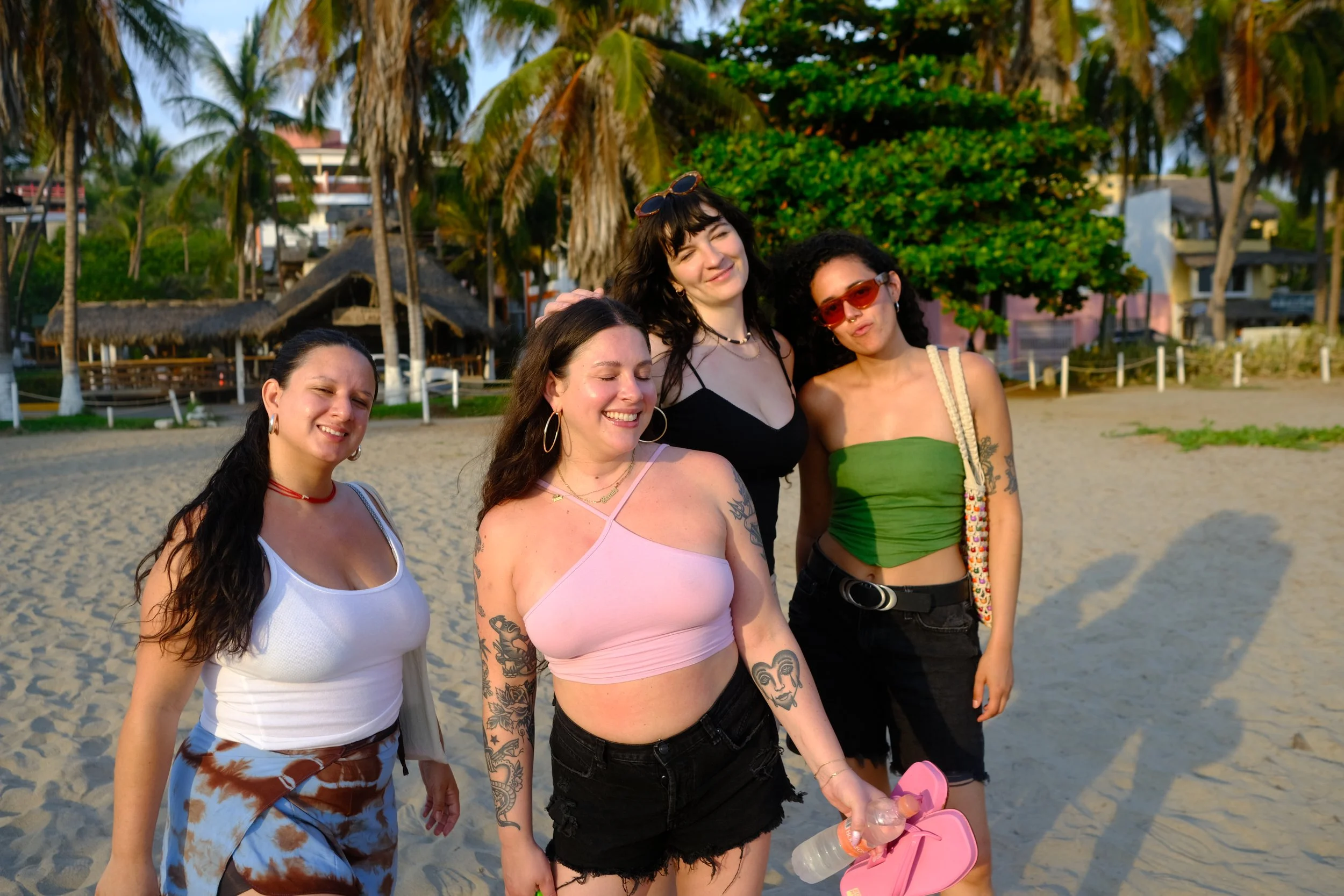 Friends smiling on the beach with palm trees, northern Zicatela, Puerto Escondido