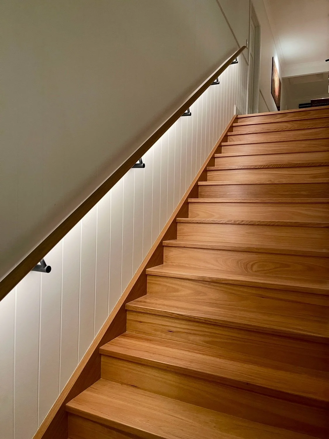 The staircase is illuminated by linear LED concealed within the handrail, providing bright, uniform light that enhances safety and highlights the form of the stairs without visible fittings. 

When lighting is integrated like this, there&rsquo;s no n