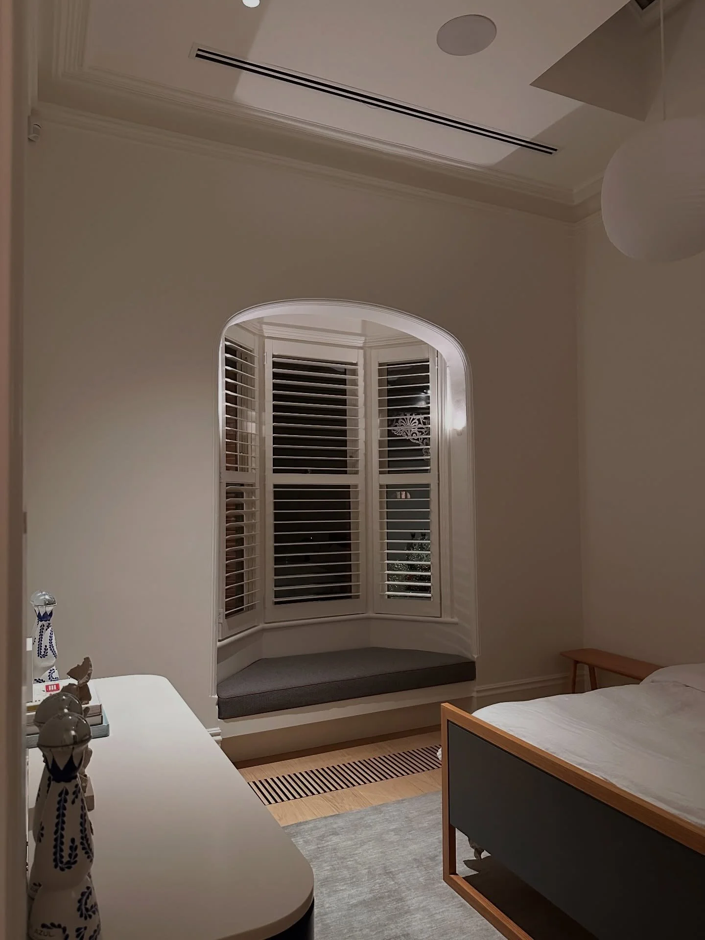 The front guest bedroom leans into the bones of the original home, with high ceilings that give it a real sense of volume. We added layers of light in to support how the room is used, making it easy to shift between rest and work without relying on a