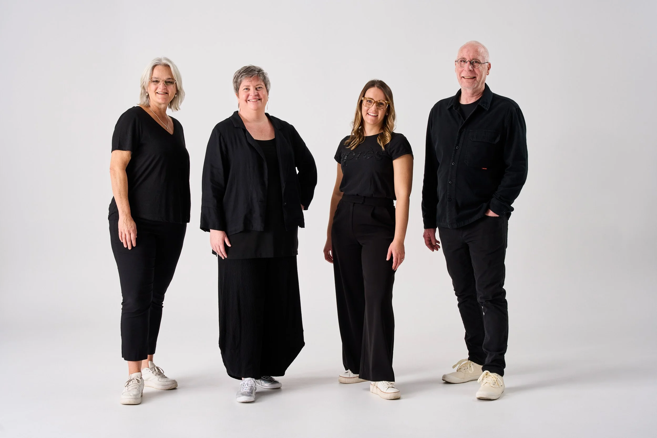 A team of four lighting designers smiling at the camera