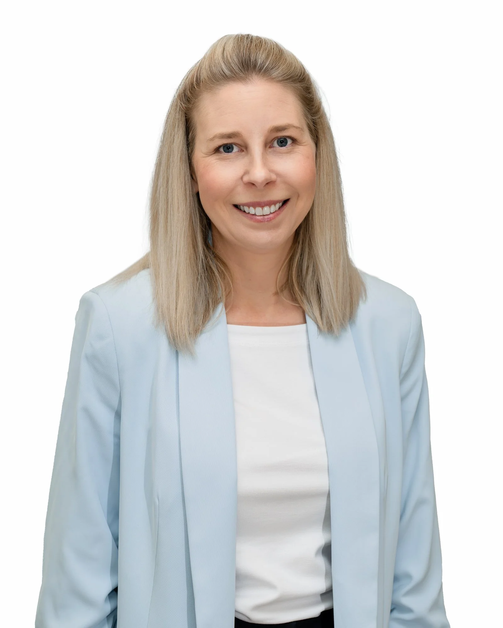 A young woman with blonde hair tied back, wearing a white collared shirt under a light blue cardigan, smiling at the camera against a white background.