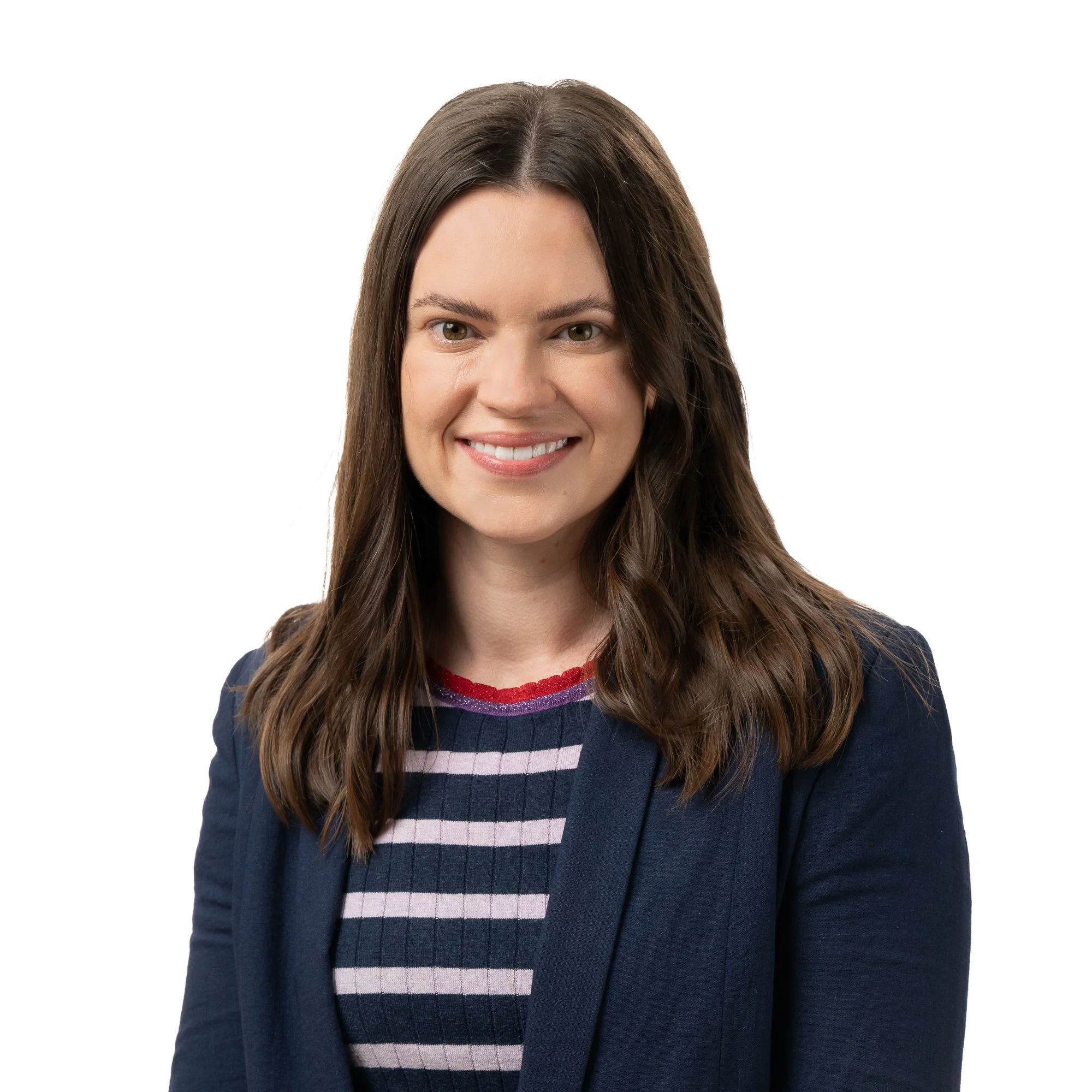 Professional woman with long brown hair smiling, wearing a navy blazer and a striped shirt, against a white background.