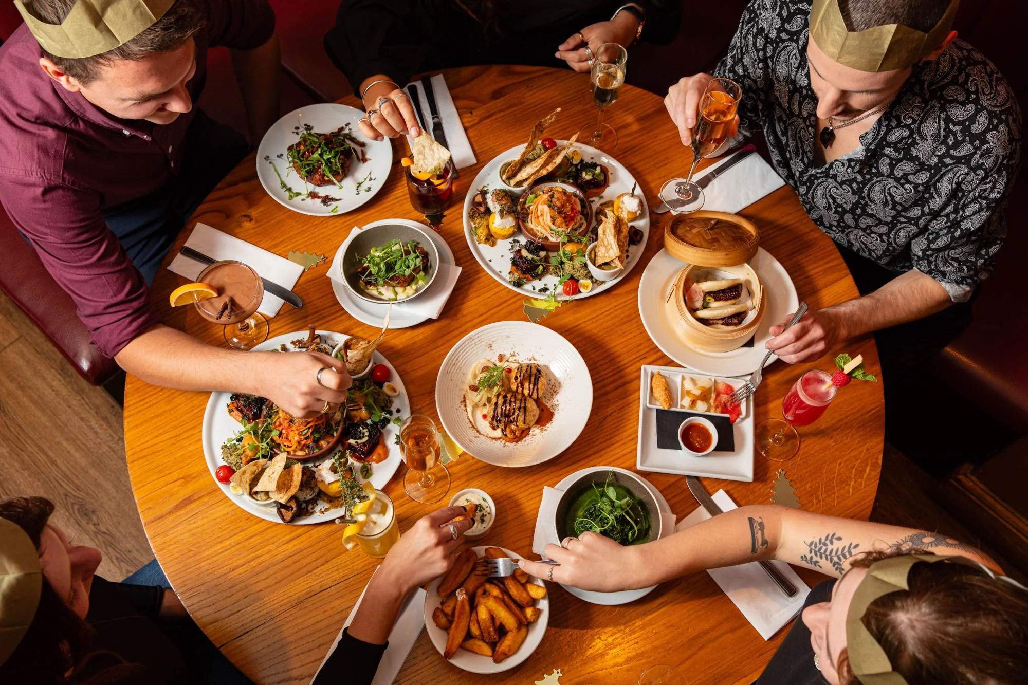 beautiful busy christmas table with happy people reaching to share food