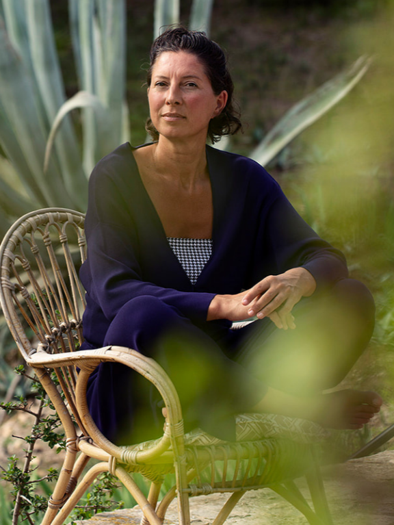 Marianne sitting outdoors in Mallorca, reflecting on her life and work as a solopreneur.