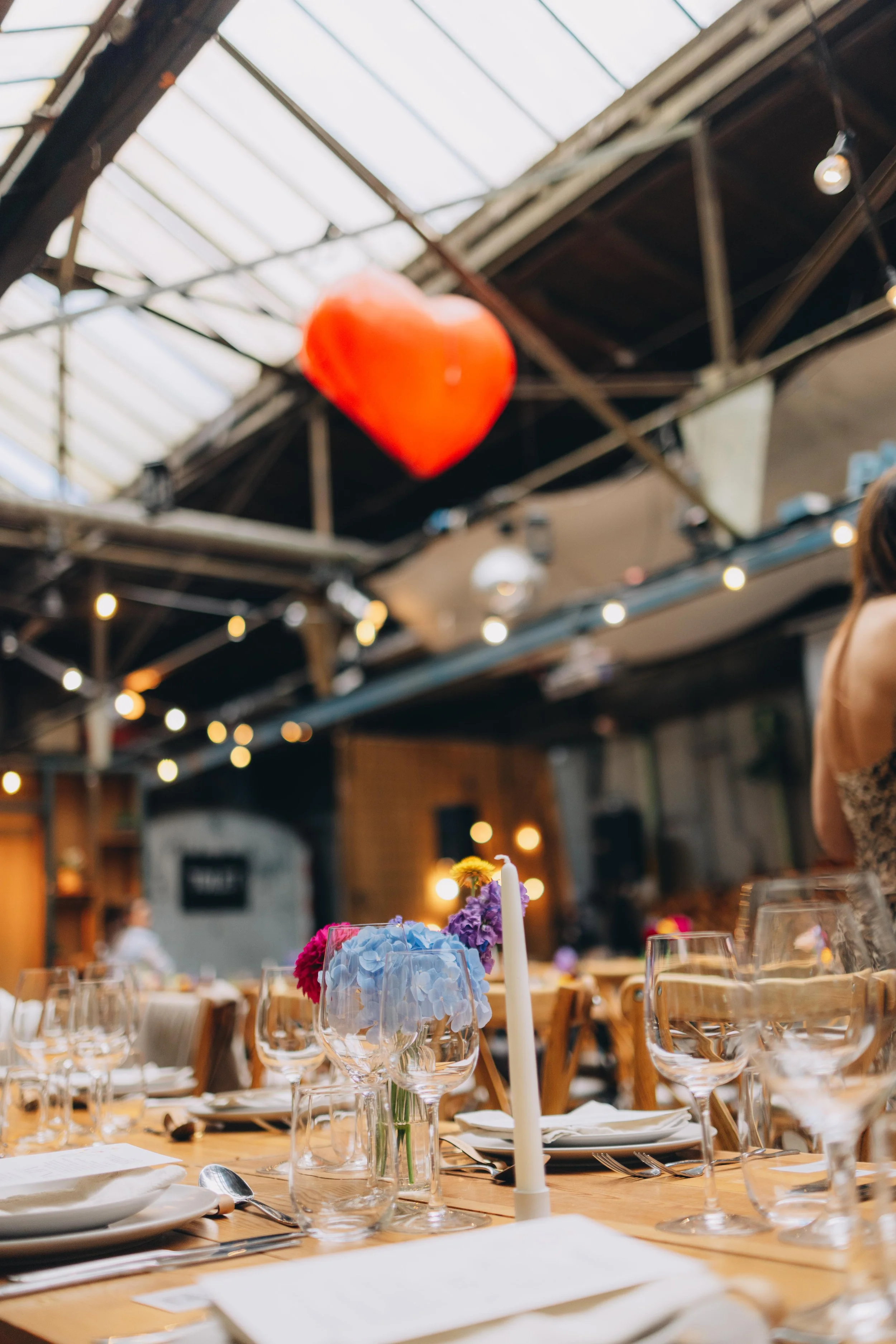 Bliss Cph – Pladeværkstedet bryllup borddækning med glas, tallerkener, bestik, blomster og stearinlys til en festlig begivenhed, med en stor hjerte