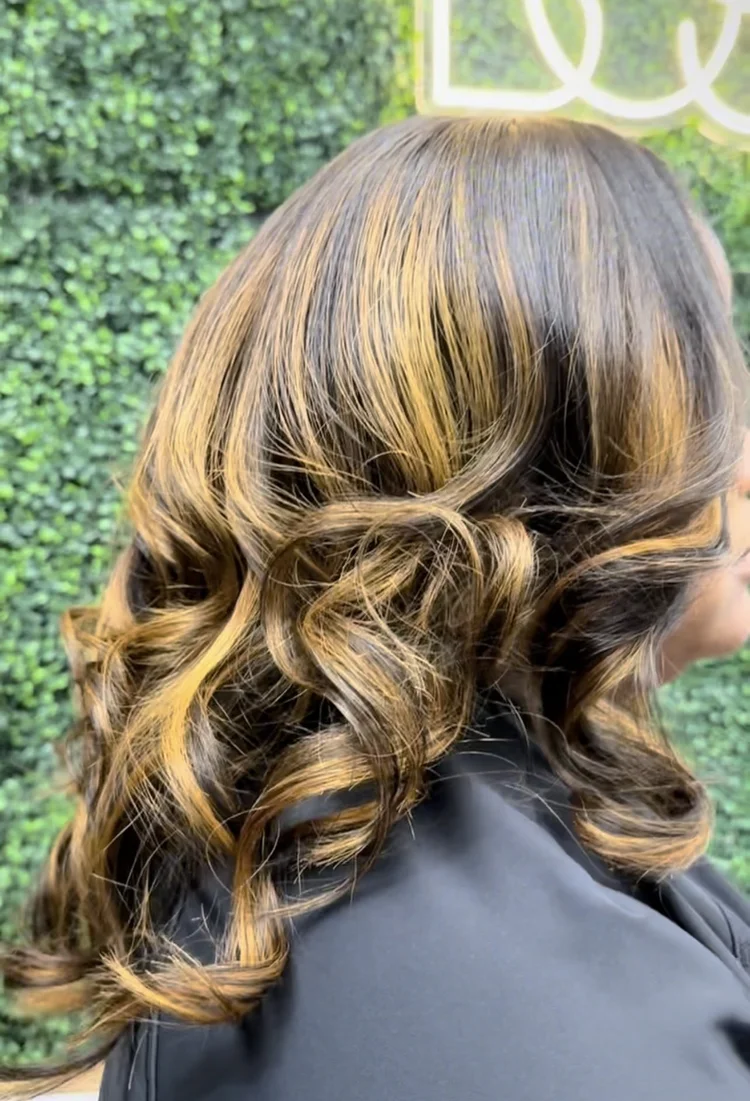 Honey-blonde highlights on voluminous curls