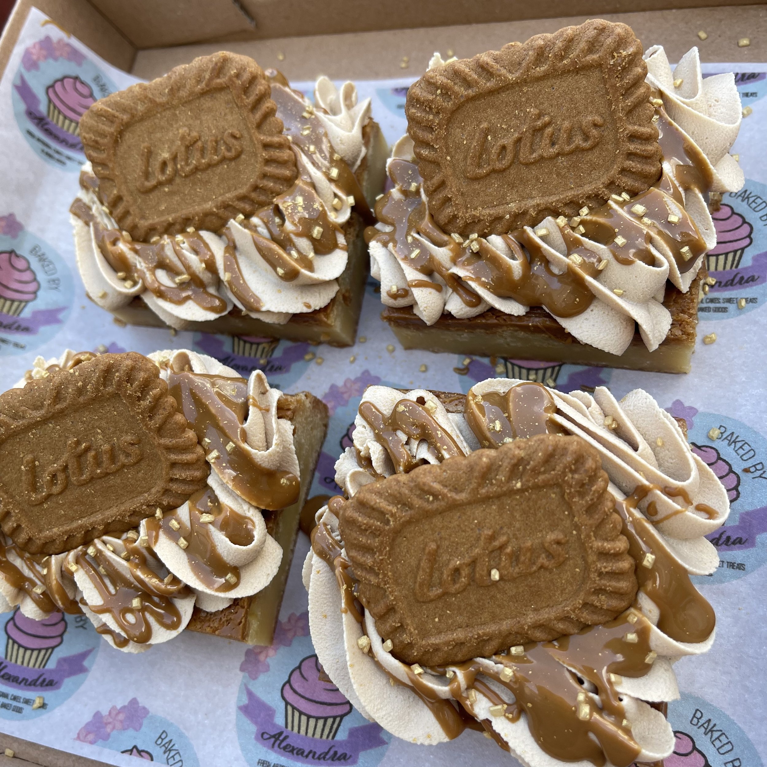 Four Biscoff Blondies topped with piped buttercream, Biscoff drizzle, and a Lotus Biscoff cookie.