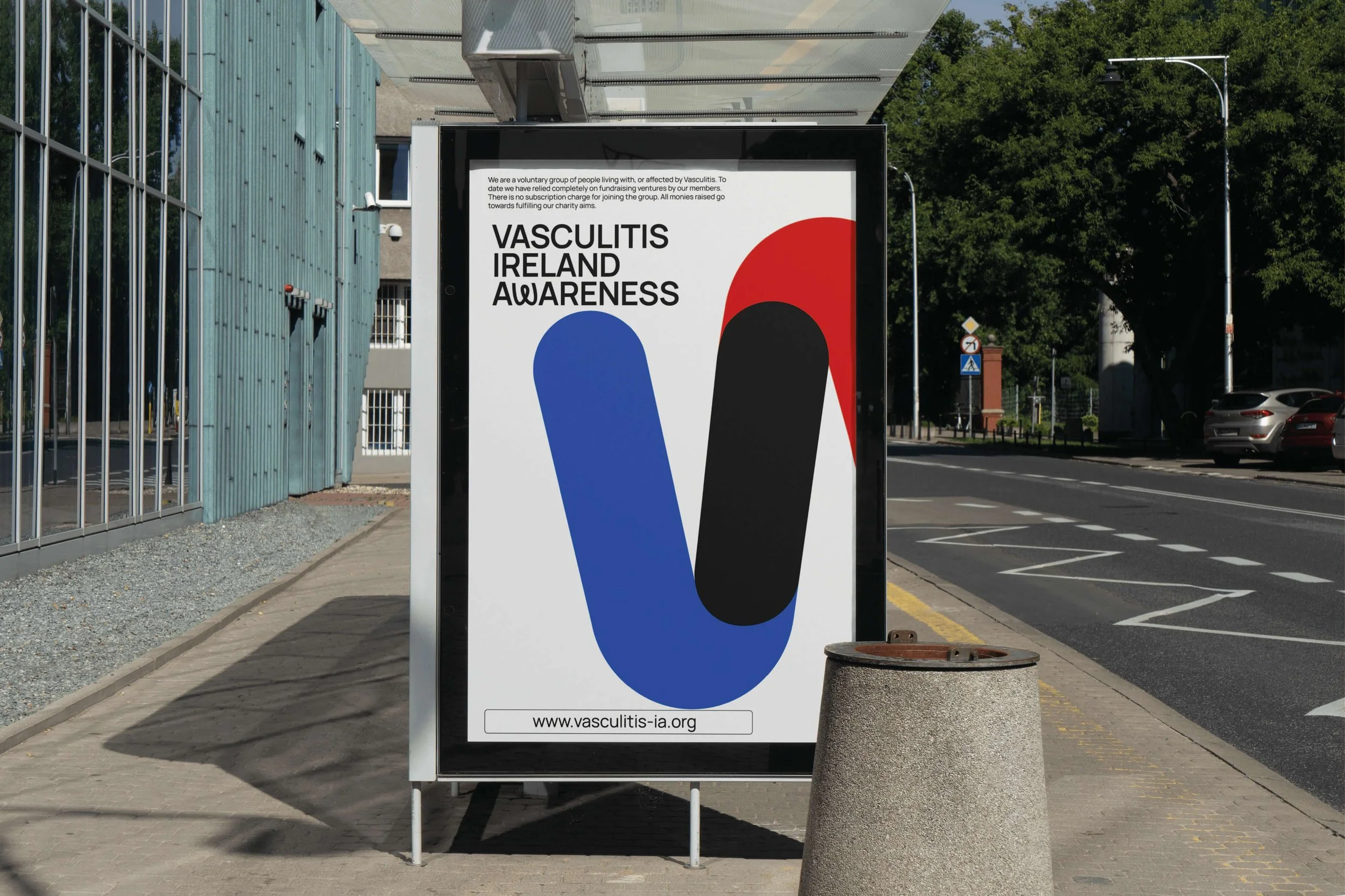A sidewalk advertisement board promoting Vasculitis Ireland Awareness with a logo consisting of a large V shape in blue and a black oval, with red and black accents on a white background.