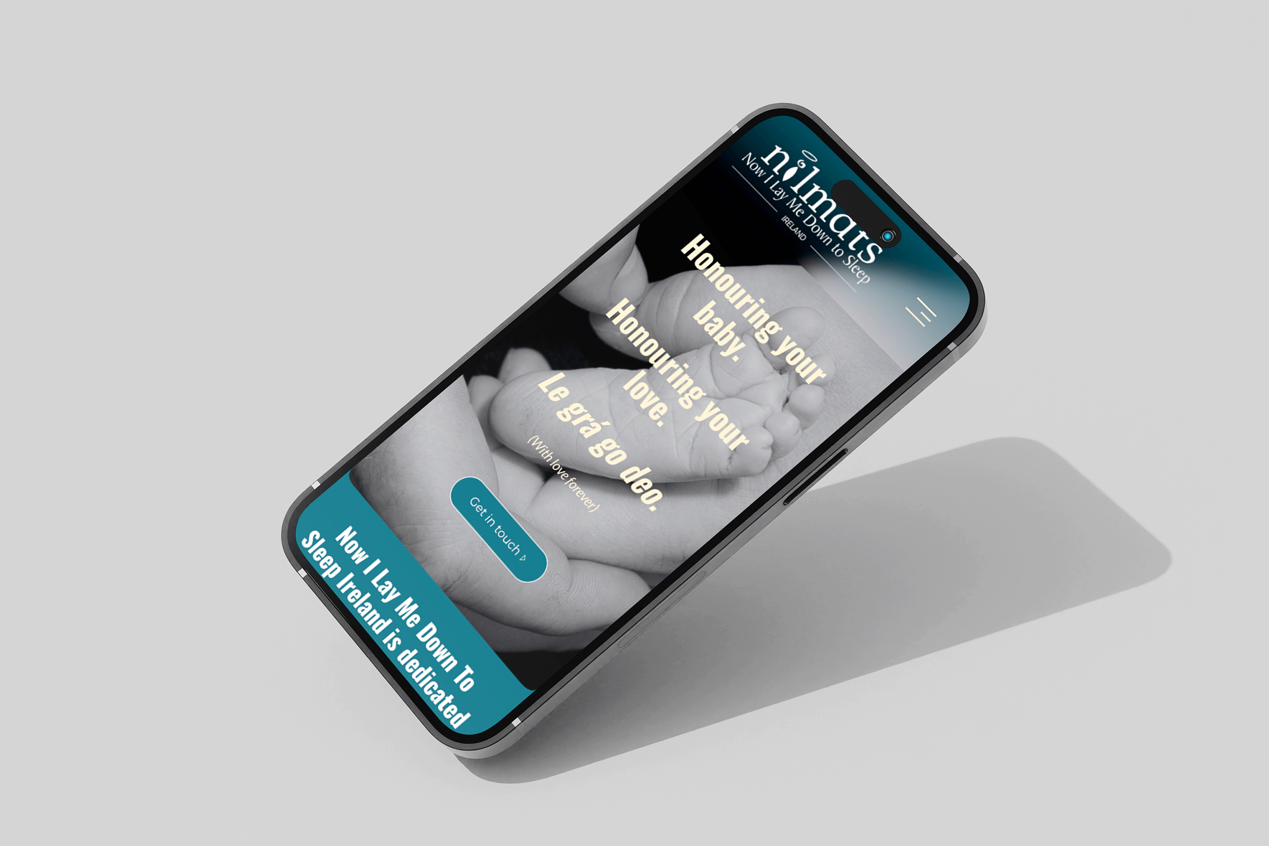 A smartphone displaying a website for 'nightmats' with a black-and-white image of a baby's hand being held by an adult's hand, and text about honoring and loving your baby, along with a blue button saying 'Get in touch' and a blue banner with white text about sleep in Ireland.