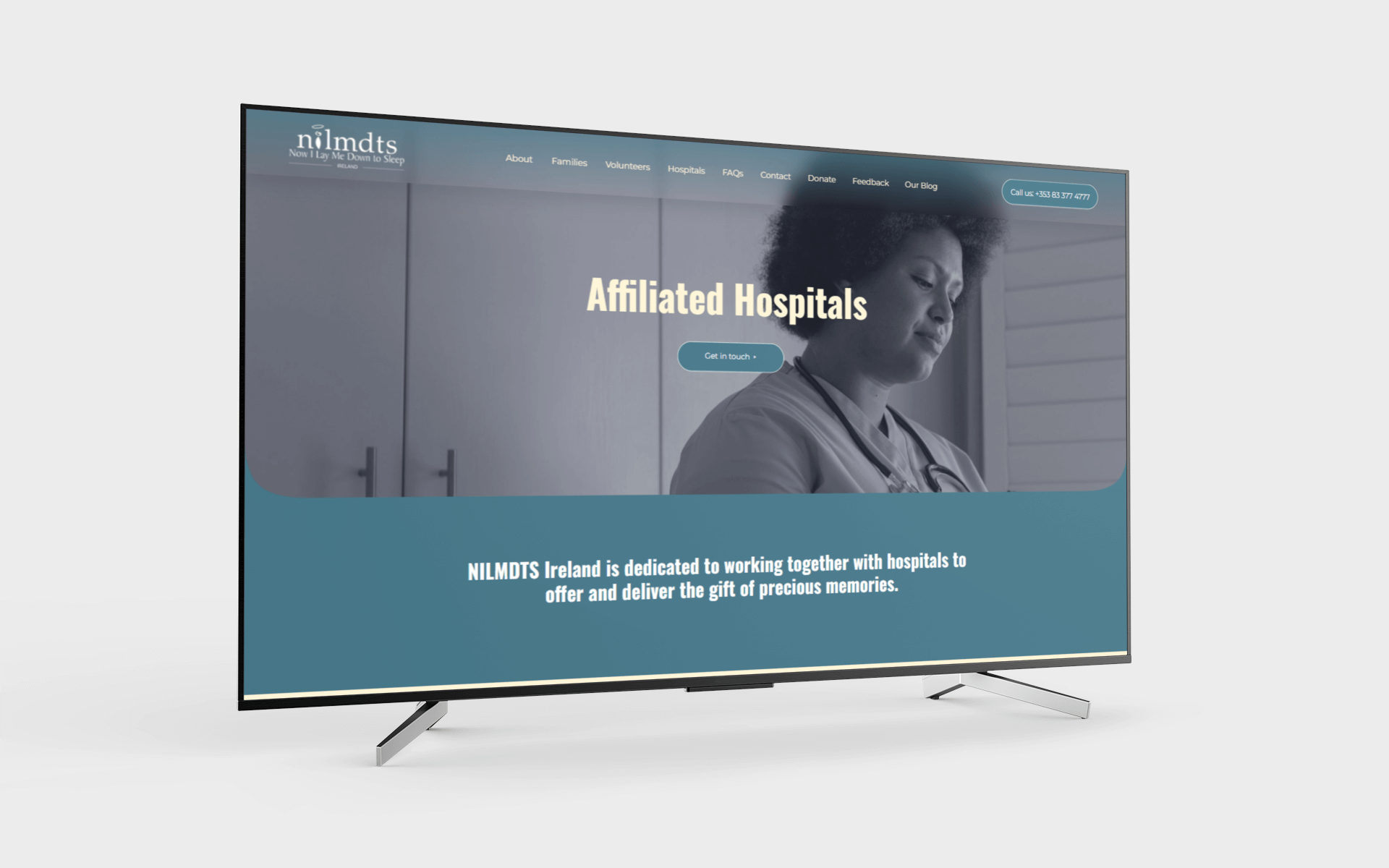 A flat-screen TV displaying a website for NILMDTS Ireland with a healthcare professional in the background, blue and white color scheme, and navigation menu at the top.