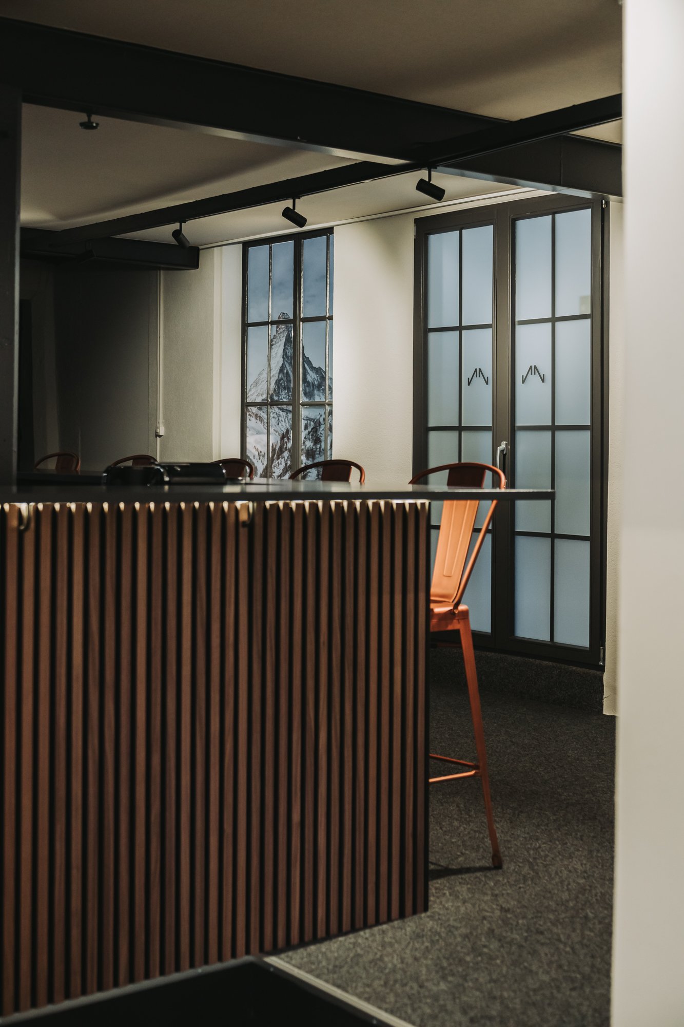 Walnut bar area in the NORQAIN LOFT office featuring LED lighting.