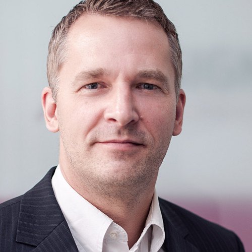 Nahaufnahme eines Mannes, Gerrit de Veer, in formeller Kleidung vor neutralem Hintergrund.