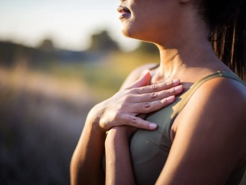 Femme pratiquant la respiration diaphragmatique en plein air pour gérer le stress