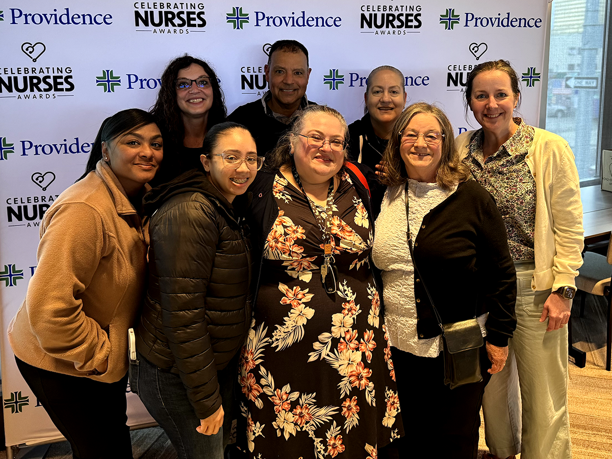Elizabeth Hill-Bryant, FNP-C, poses with ANHC coworkers in front of a Celebrating Nurses Awards backdrop.