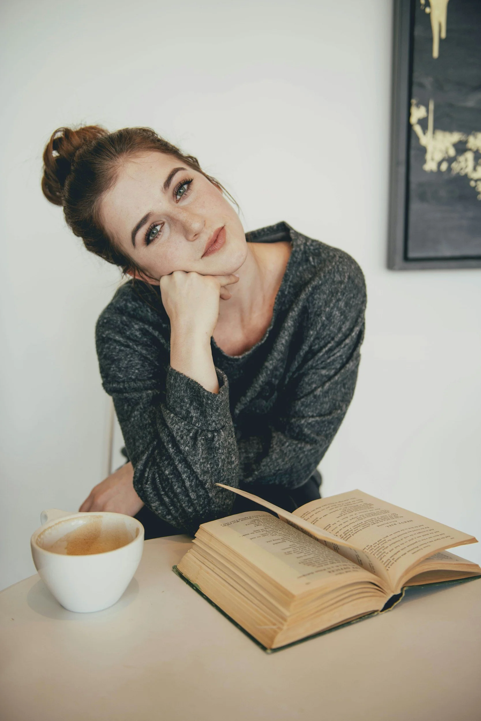 Woman reading with coffee at table, representing self-reflection, personal growth, and processing emotions through therapy