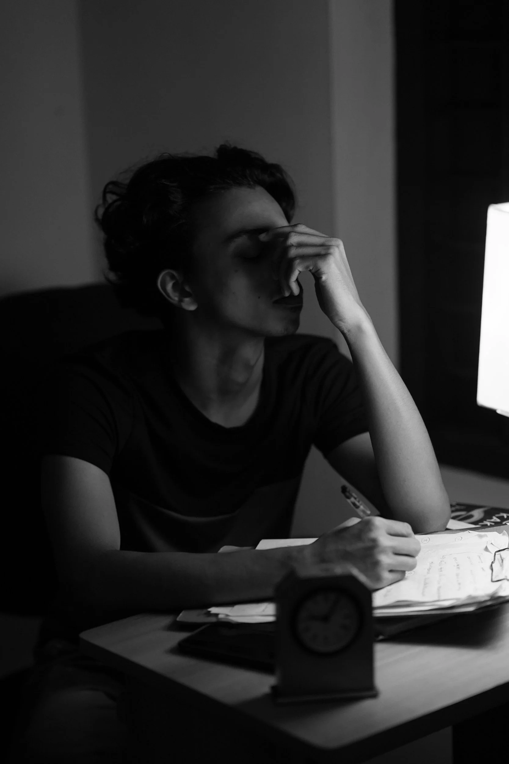 Woman sitting at a desk feeling overwhelmed and stressed, representing emotional overwhelm, anxiety, and mental exhaustion addressed in therapy