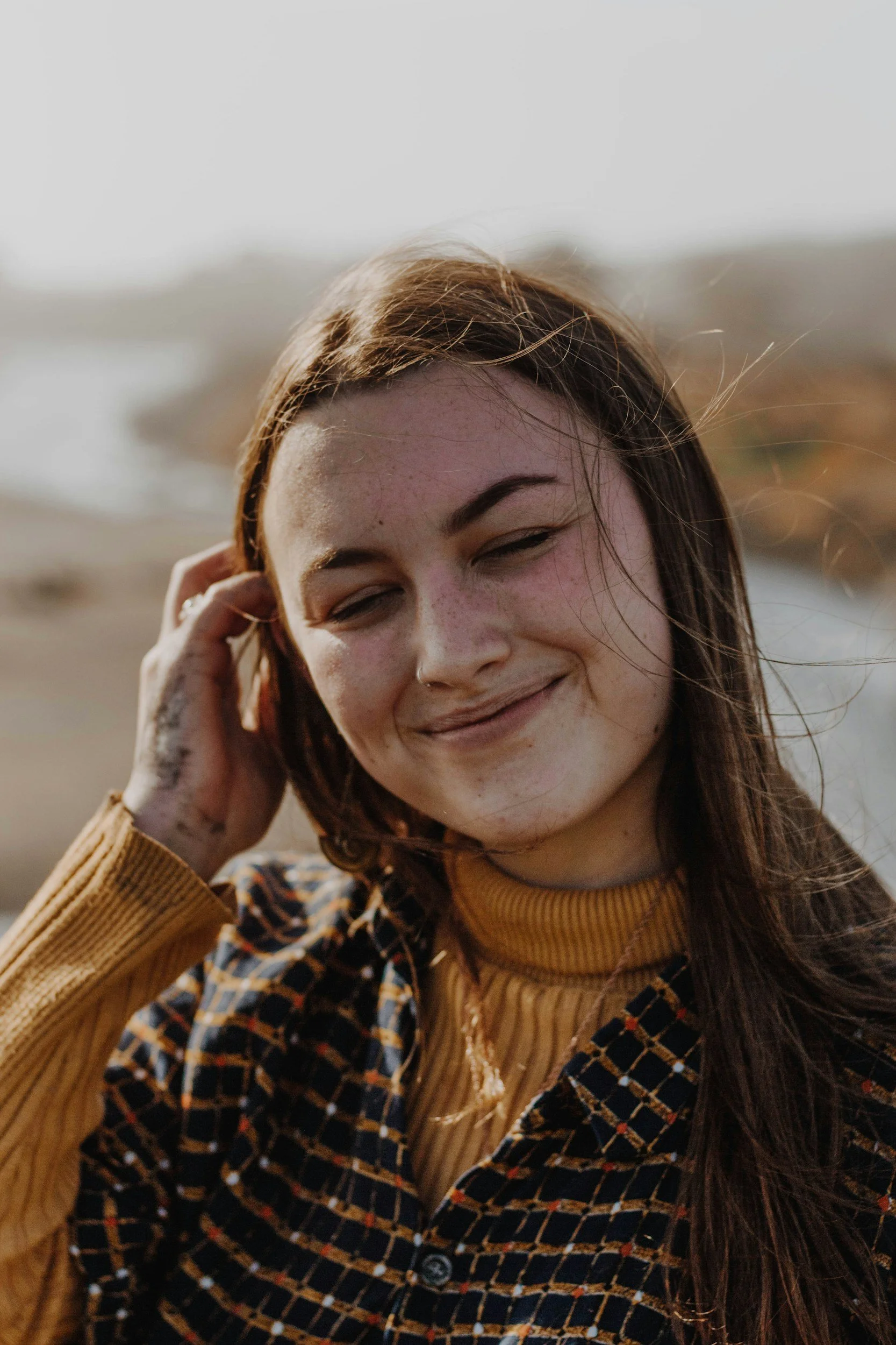 Woman smiling softly outdoors, representing emotional healing, self-trust, and reduced anxiety after therapy