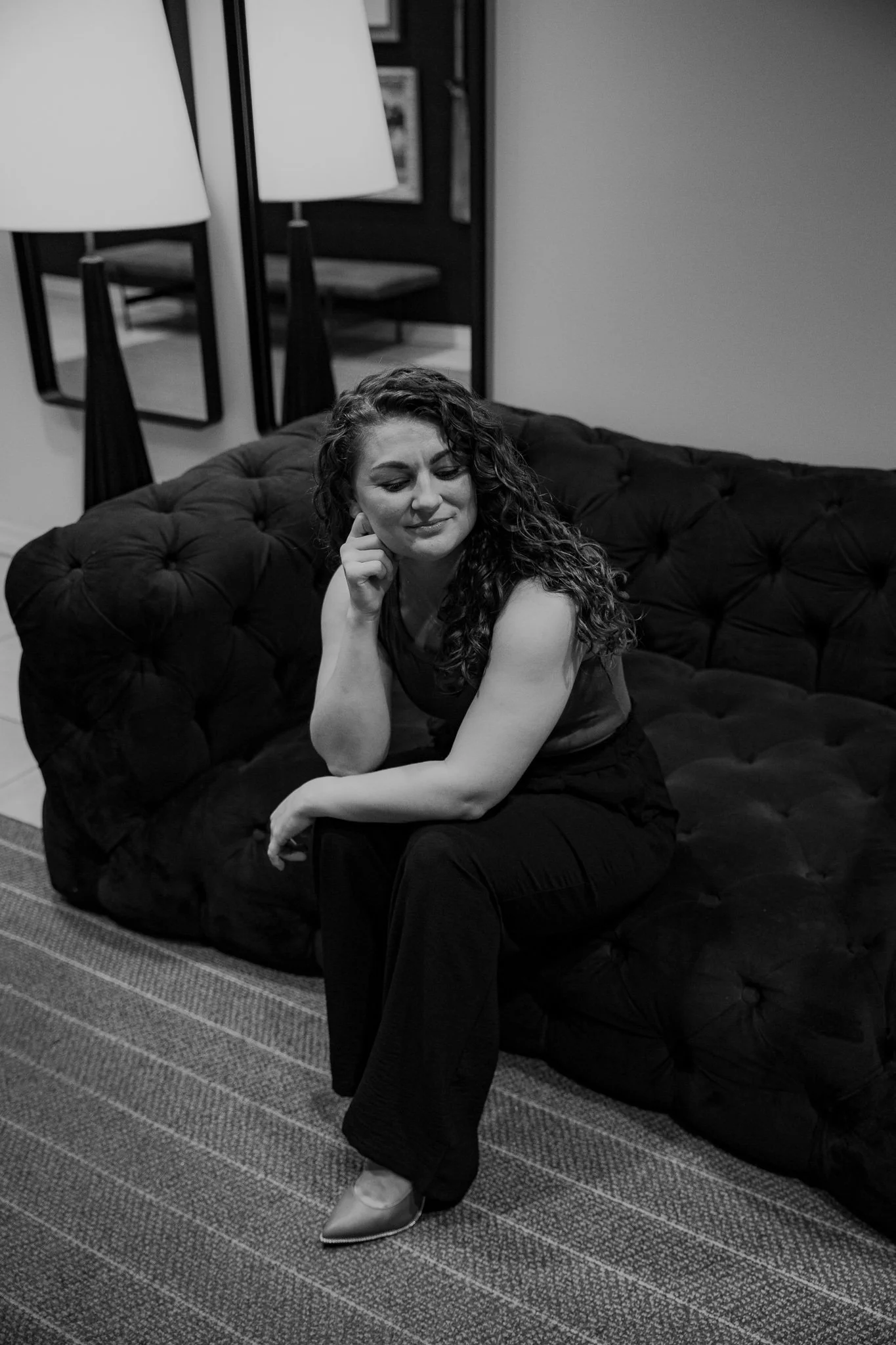 Therapist sitting on couch in calm office space, representing support for anxiety, attachment wounds, and relationship healing in Michigan