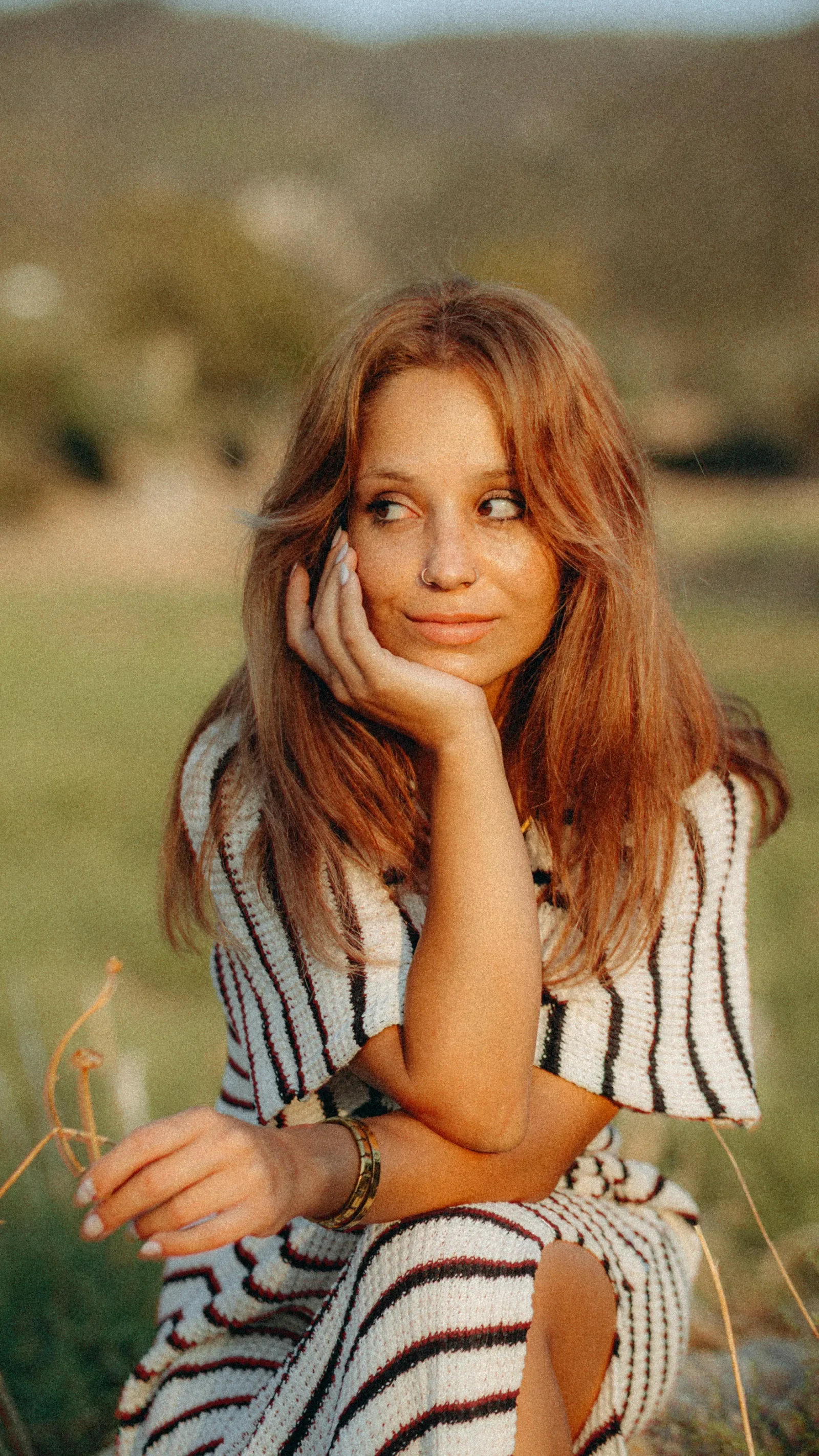 Woman relaxing outdoors at sunset, reflecting the whole-person approach of holistic women's wellness care