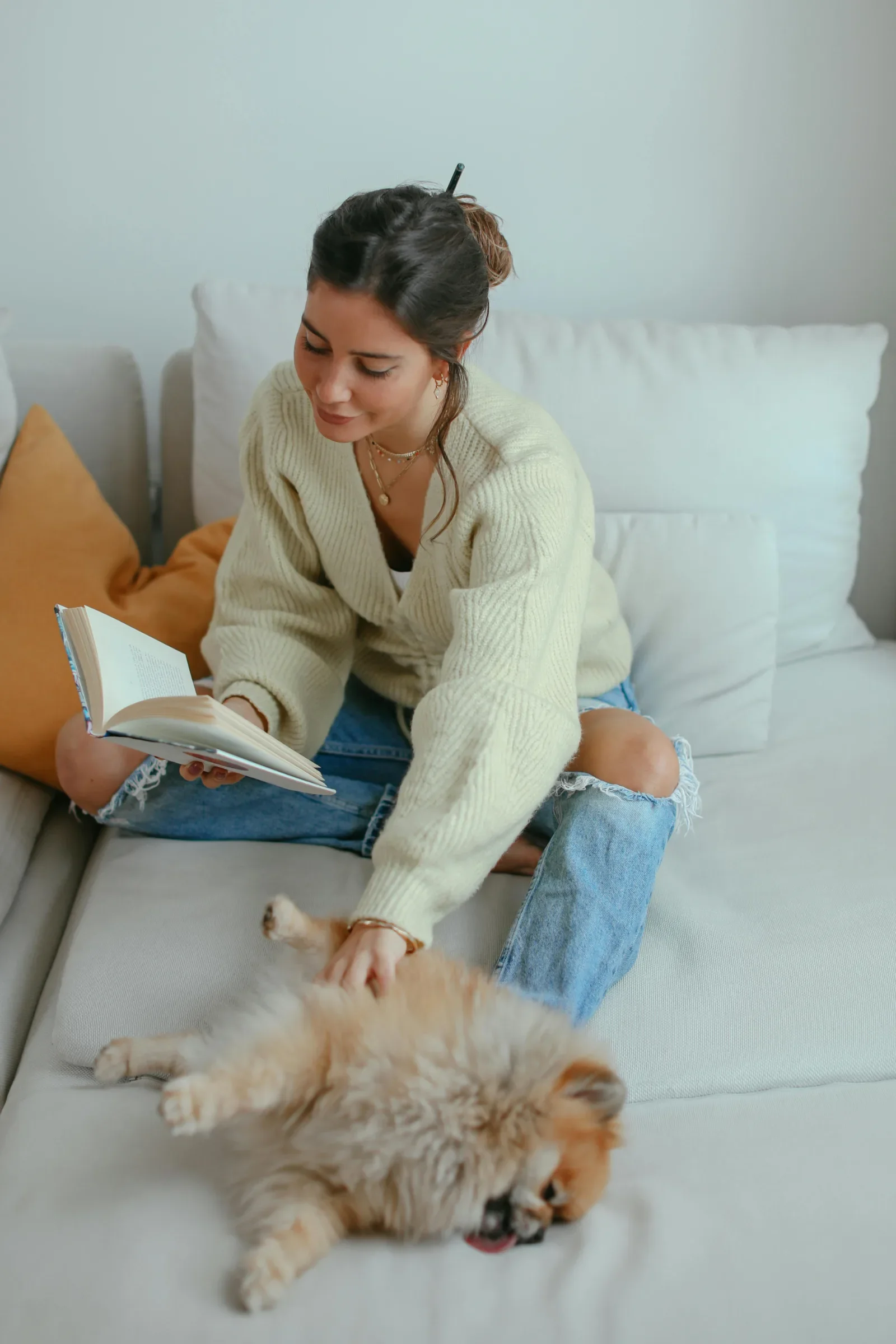 Woman relaxing with a book and her dog, practicing self-compassion while healing from an emotionally immature family in therapy