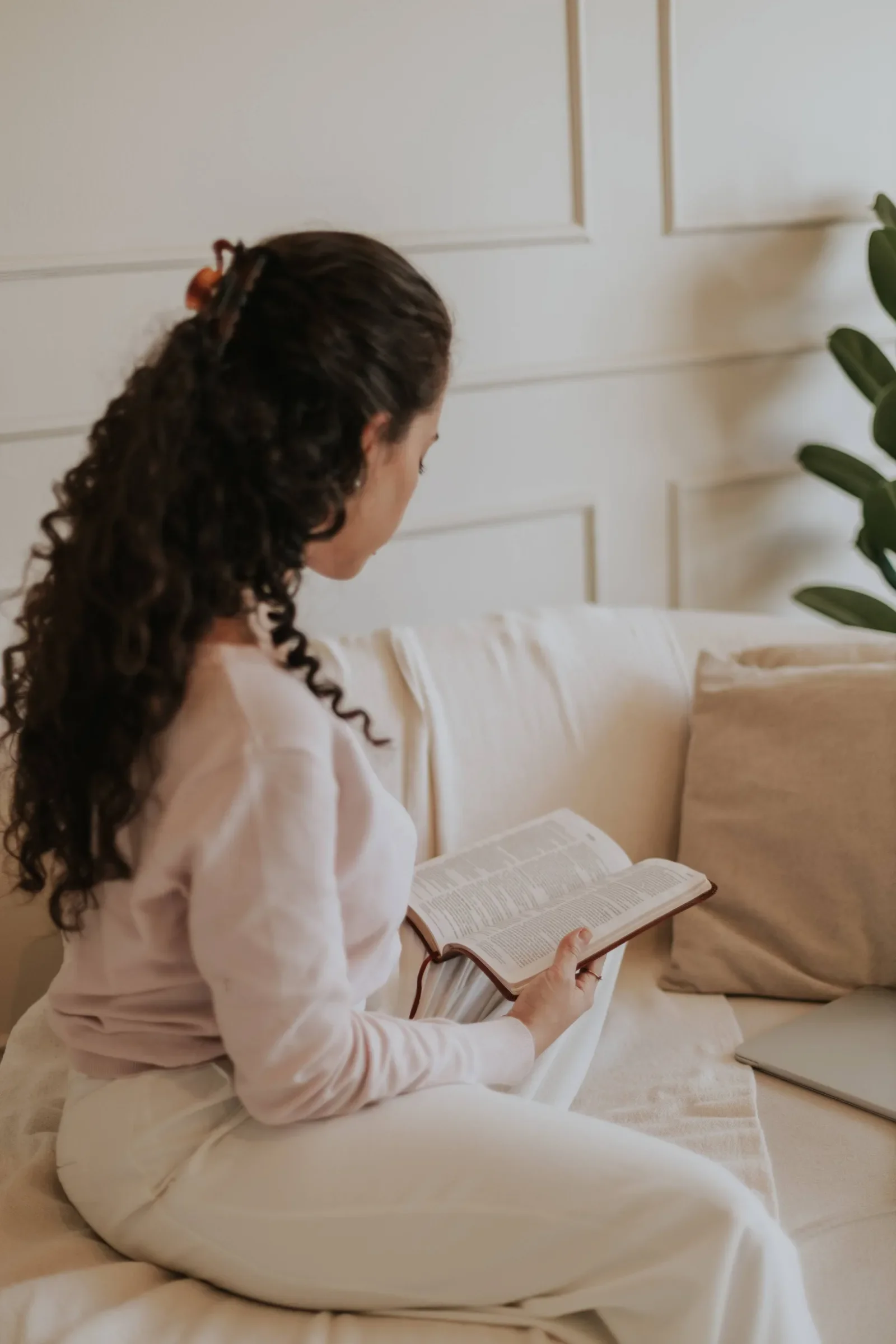 Woman reading her Bible on a sofa during a faith-based therapy session