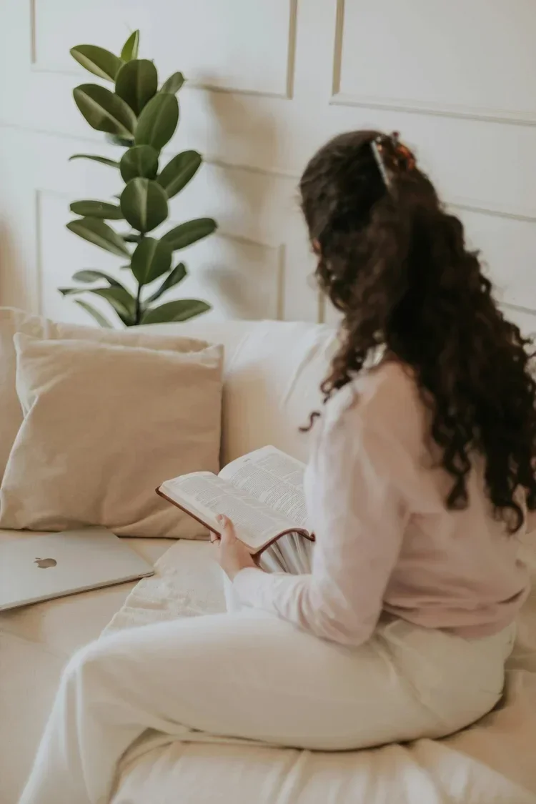 Woman reading her Bible at home, integrating scripture and faith into her Christian counseling journey