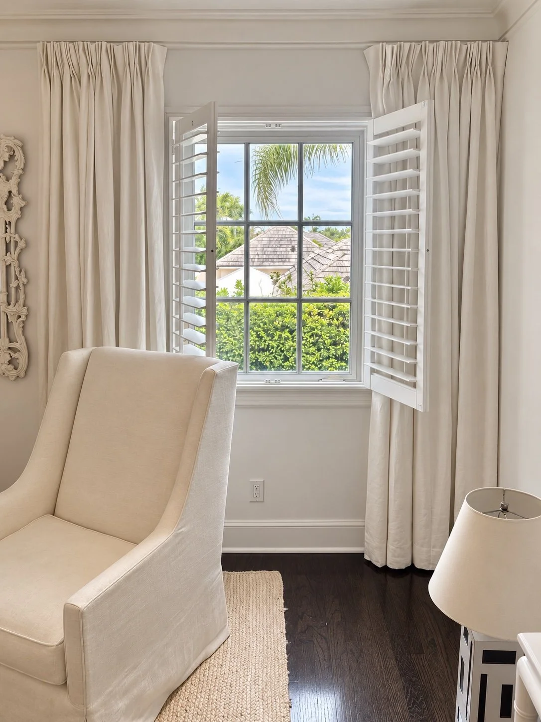 Plantation shutters opened to frame a bright bedroom view