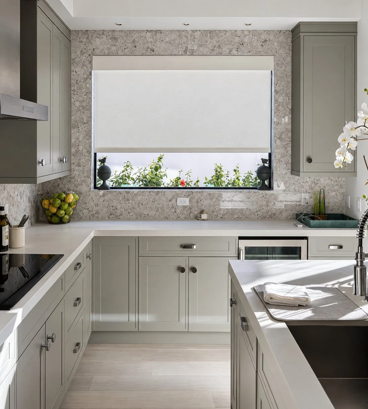White roller shade across a wide kitchen window