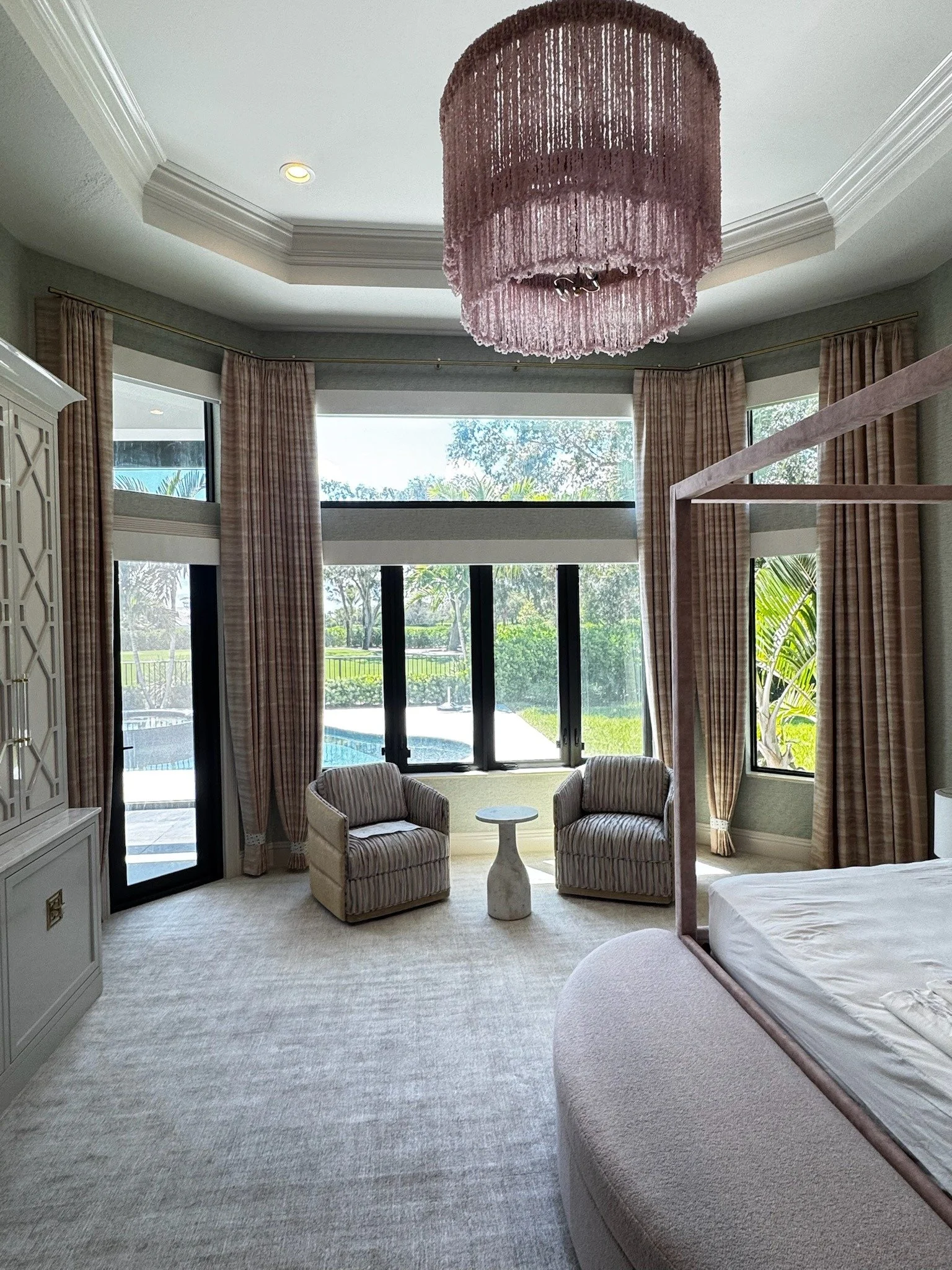 Blush bedroom drapery paired with Roman shades.