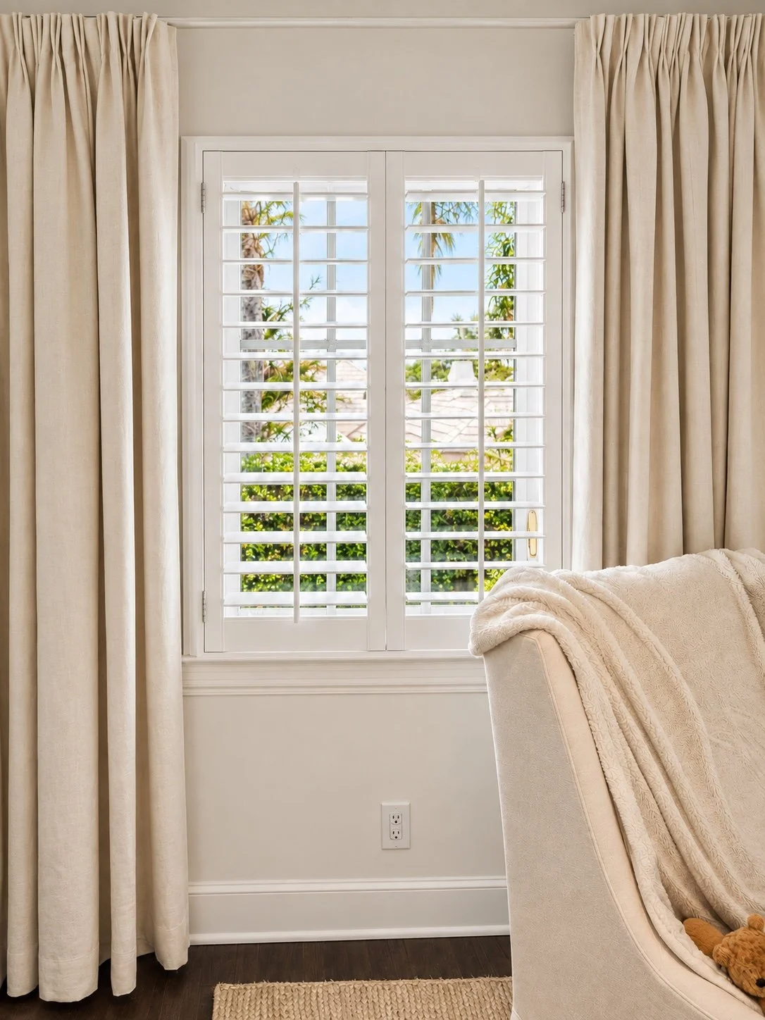 White plantation shutters paired with soft neutral drapery
