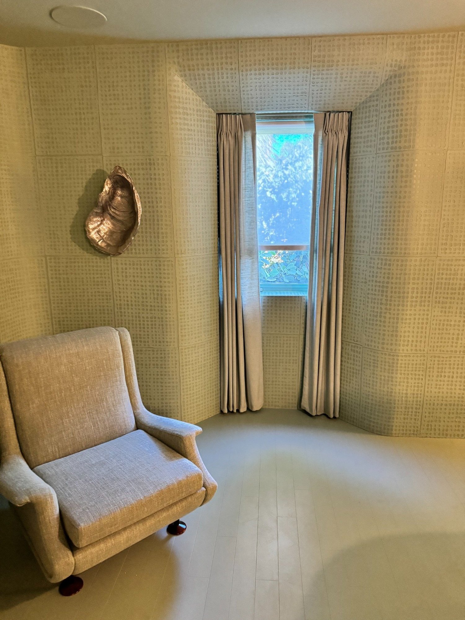 Neutral drapery framing a reading nook window