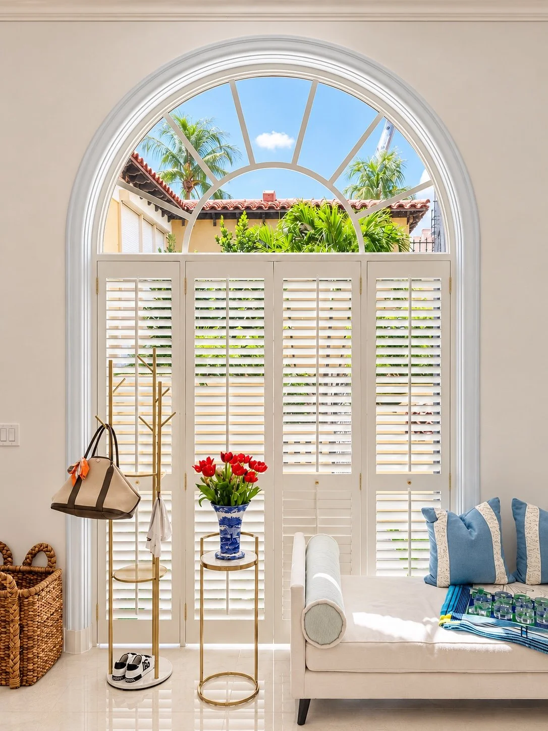 Plantation shutters fitted beneath a dramatic arched transom window.